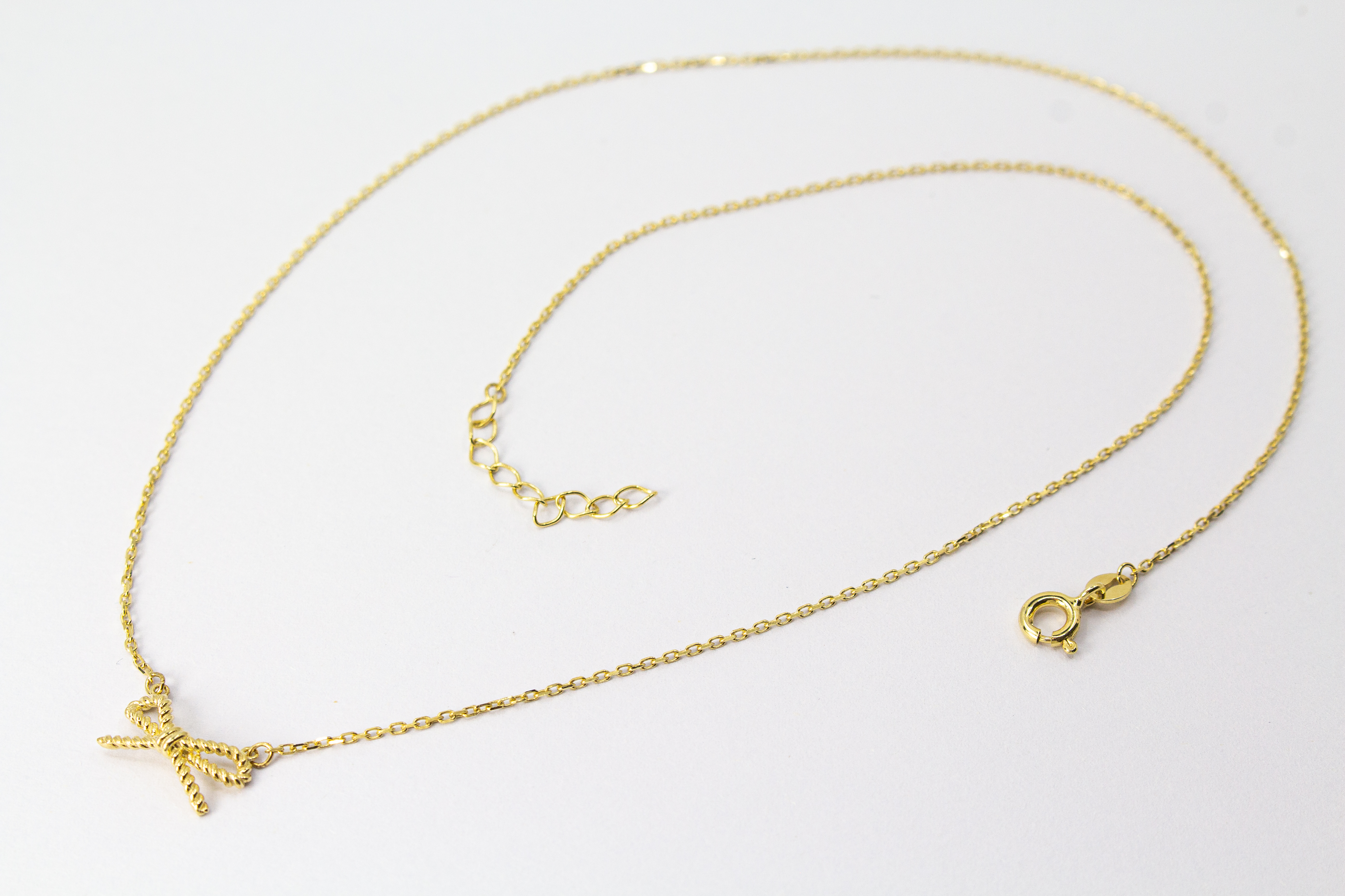 Collier „Schleifenzauber“ aus vergoldetem 925er Sterlingsilber mit filigranem Schleifenanhänger in elegantem, zeitlosem Design.