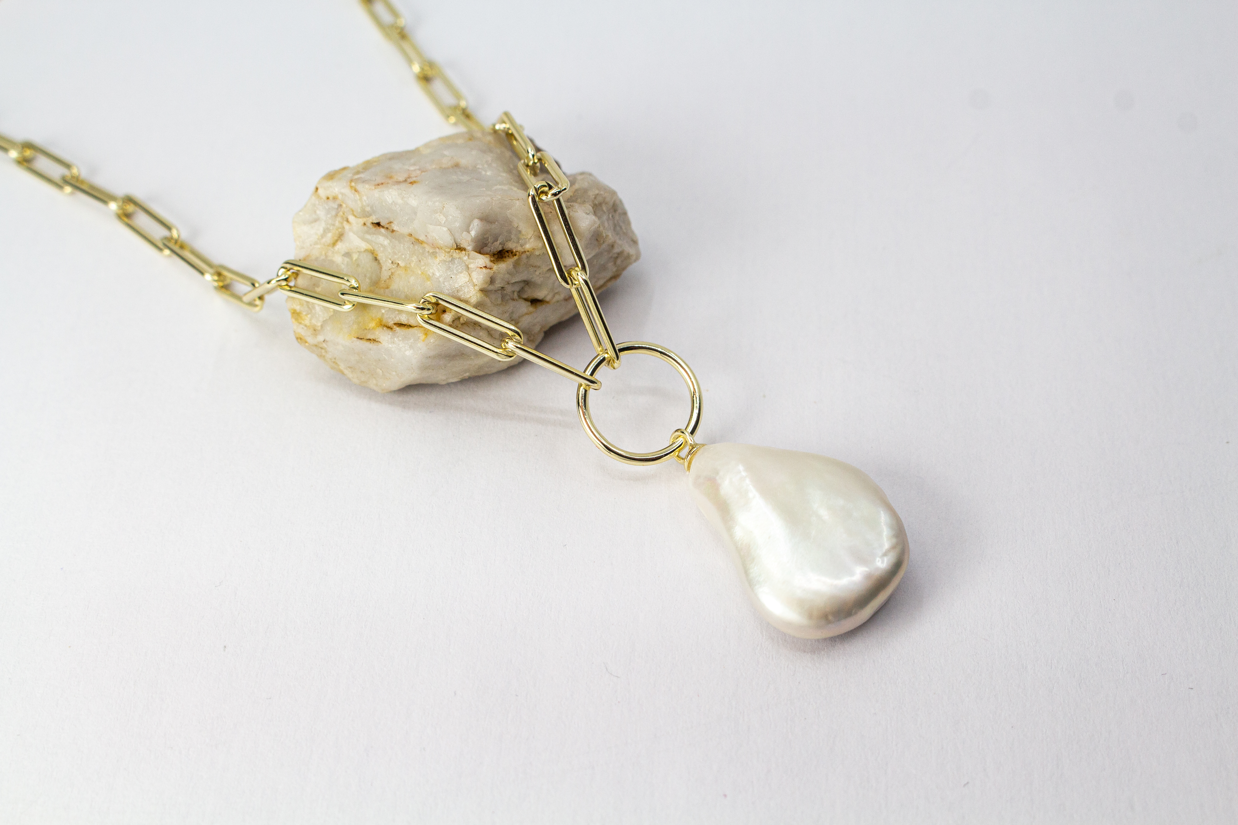Eine filigrane, hochwertig gelbvergoldete Halskette aus 925er Sterlingsilber von der Goldschmiede Regina Kraus. Als Anhänger dient eine edle, weiße Barock-Zuchtperle mit ihrer typischen, unregelmäßig gewachsenen Form und einem intensiv schimmernden Lüster