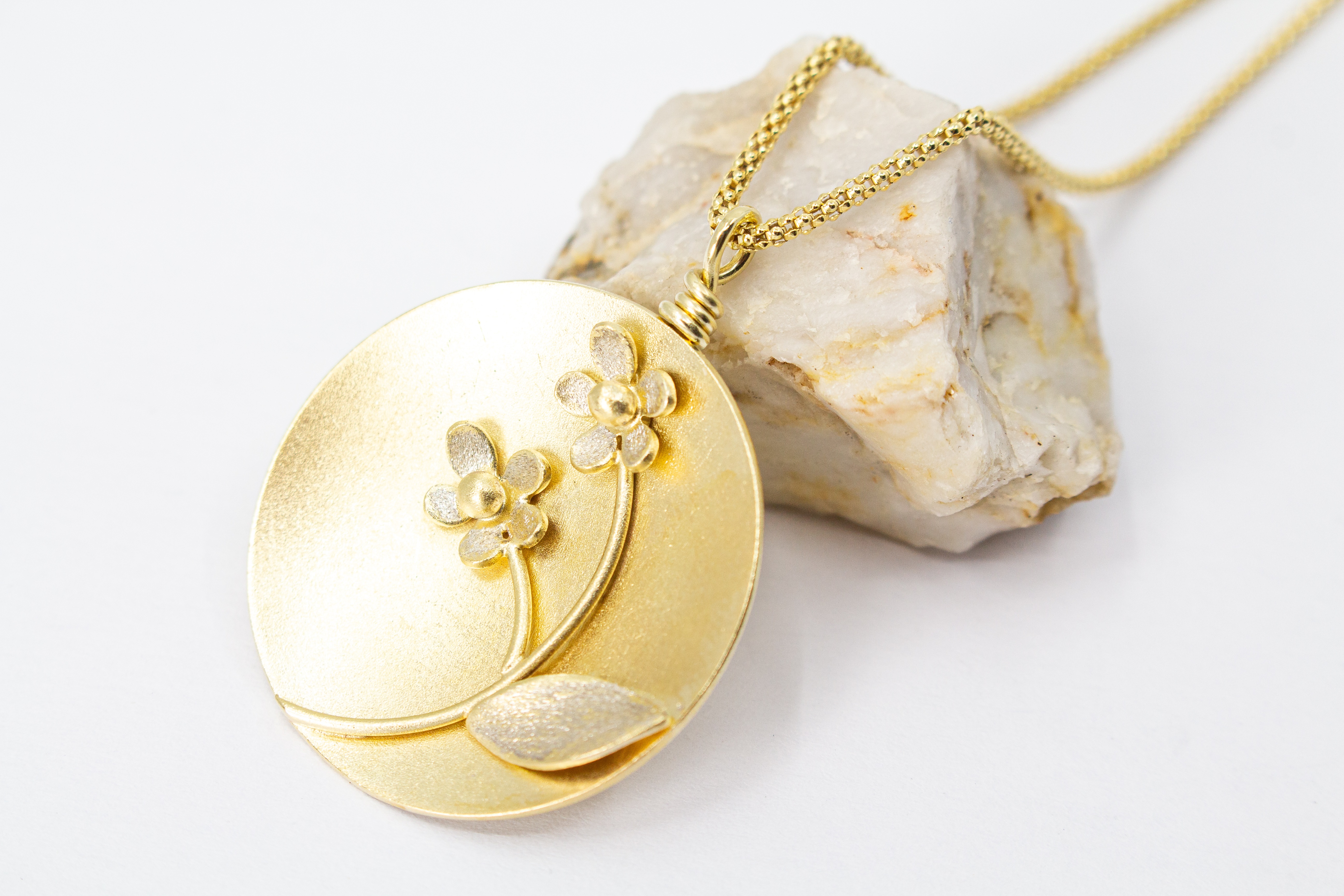 Feine Halskette mit rundem, matt vergoldetem Medaillon-Anhänger aus 20 Mikron plattiertem 925er Sterlingsilber, verziert mit einem plastischen Blumen-Motiv mit zwei Blüten und einem Blatt