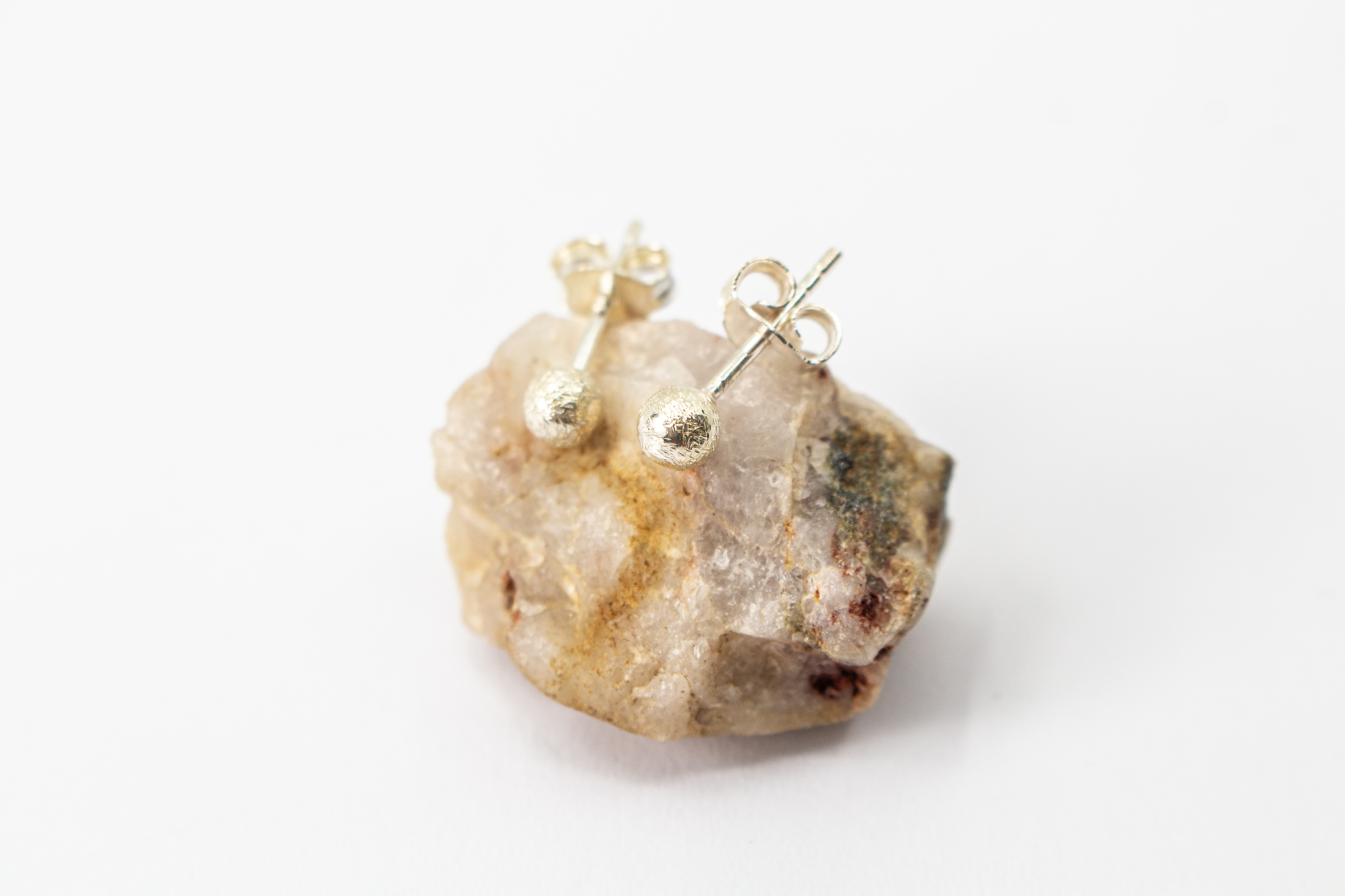 Klassische Kugel-Ohrstecker aus Silber mit mattierter, strukturierter Oberfläche im Onlineshop von Goldschmiede Regina Kraus.