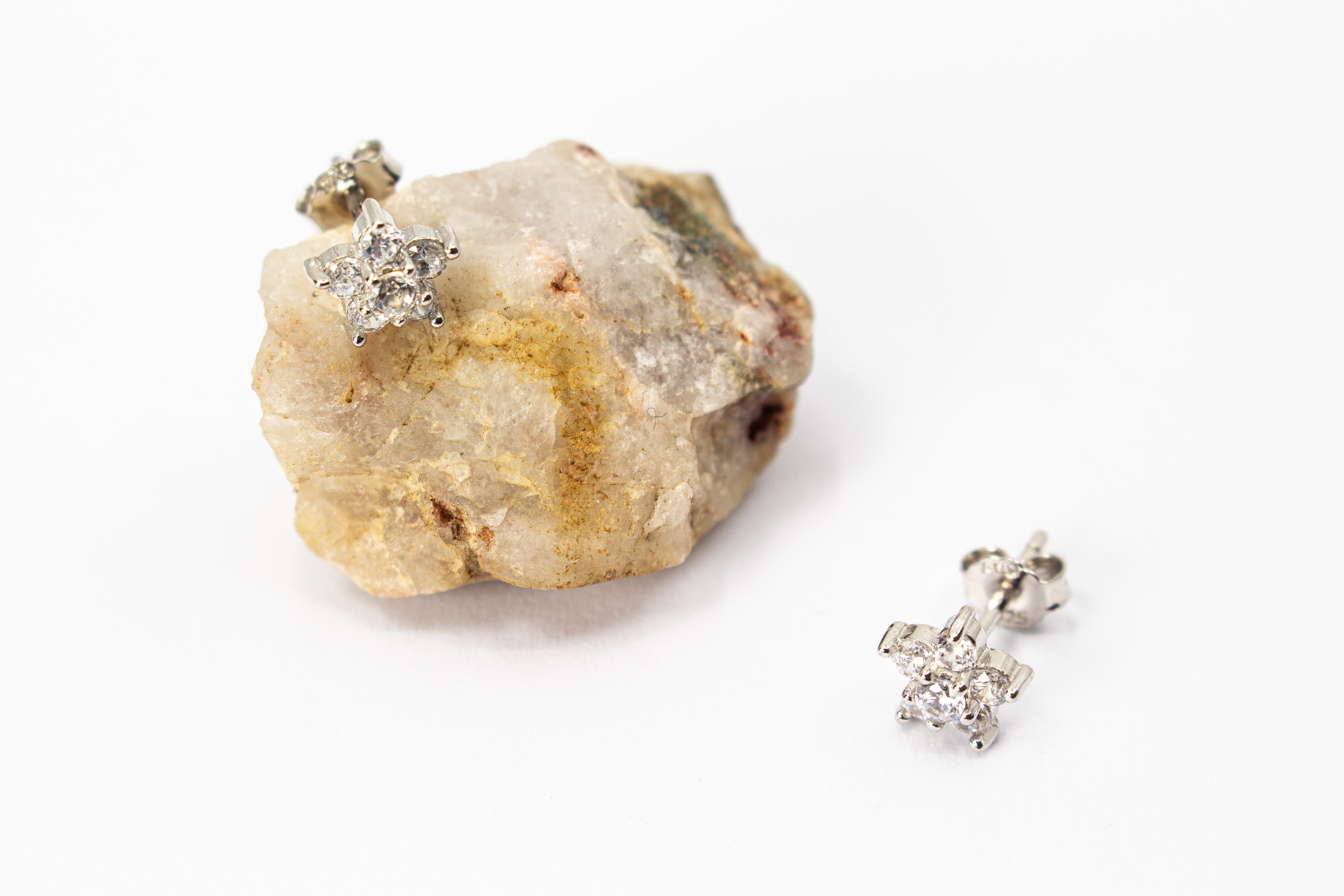 Filigrane Blumen-Ohrstecker aus rhodiniertem 925er Silber in Form einer kleinen Blüte mit funkelndem Zirkonia-Besatz im Onlineshop von Goldschmiede Regina Kraus.
