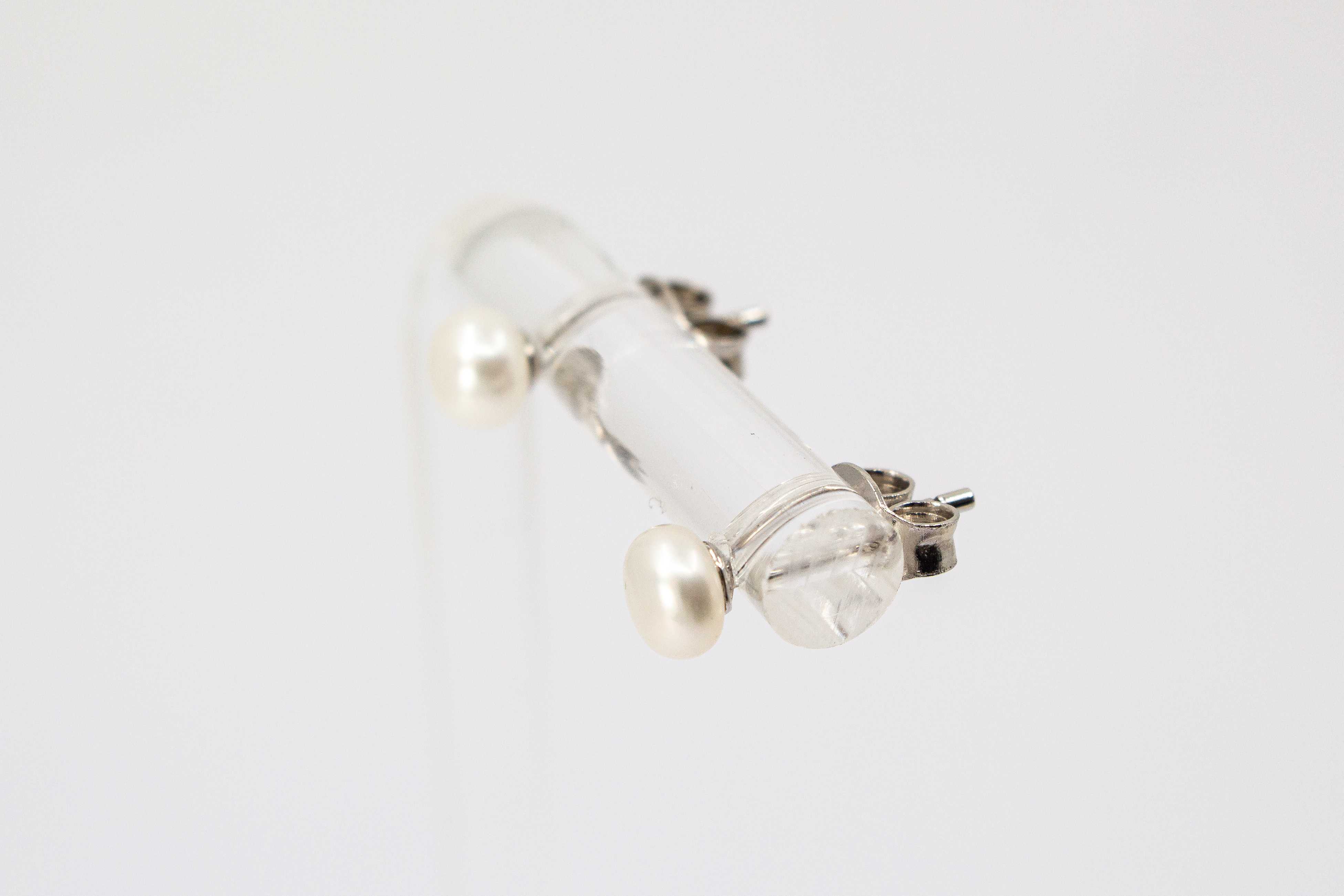 Ein Paar klassische Perlenohrstecker aus 925er Sterlingsilber mit je einer runden, weiß schimmernden Süßwasserzuchtperle