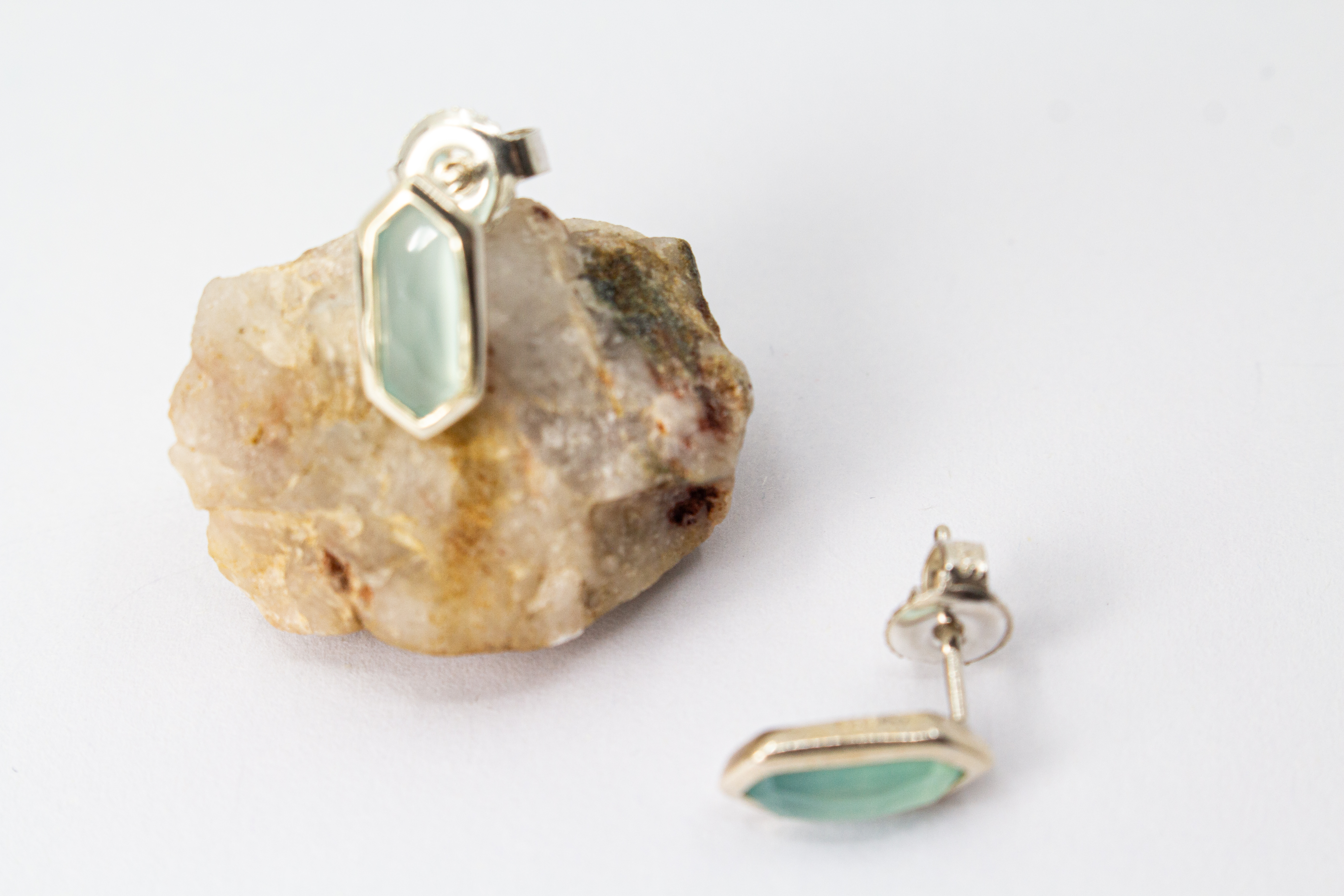 geometrische Ohrstecker aus glänzendem 925 Sterling Silber mit einem facettierten, sechseckigen Chalcedon-Edelstein in hellem Pastellblau aus dem Online-Shop der Goldschmiede Regina Kraus.