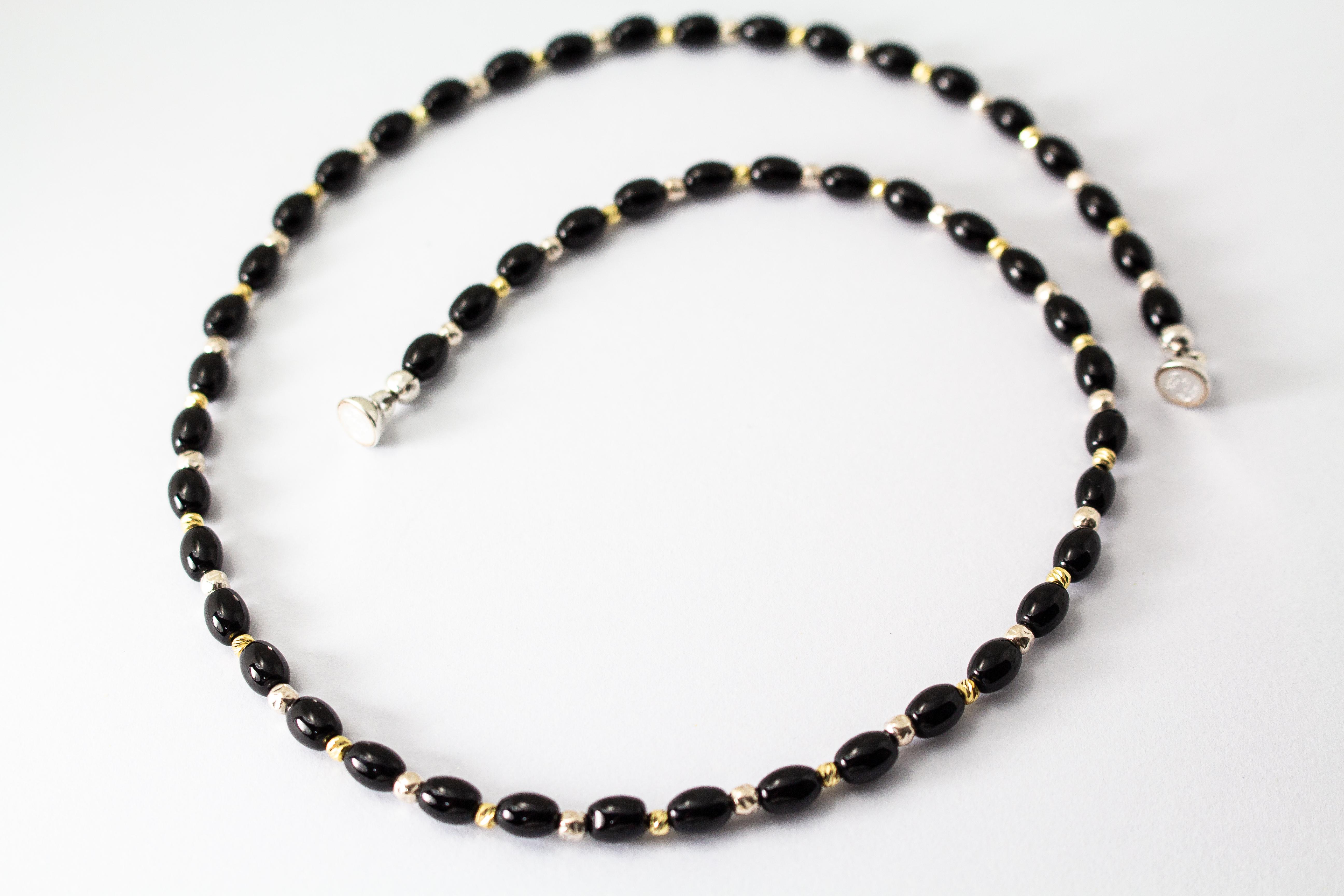 Elegante Onyx Kette „Mitternachtsglanz“ mit schwarzen Onyx-Perlen, Zwischenteilen aus 925er Sterlingsilber und vergoldeten Silberdetails.