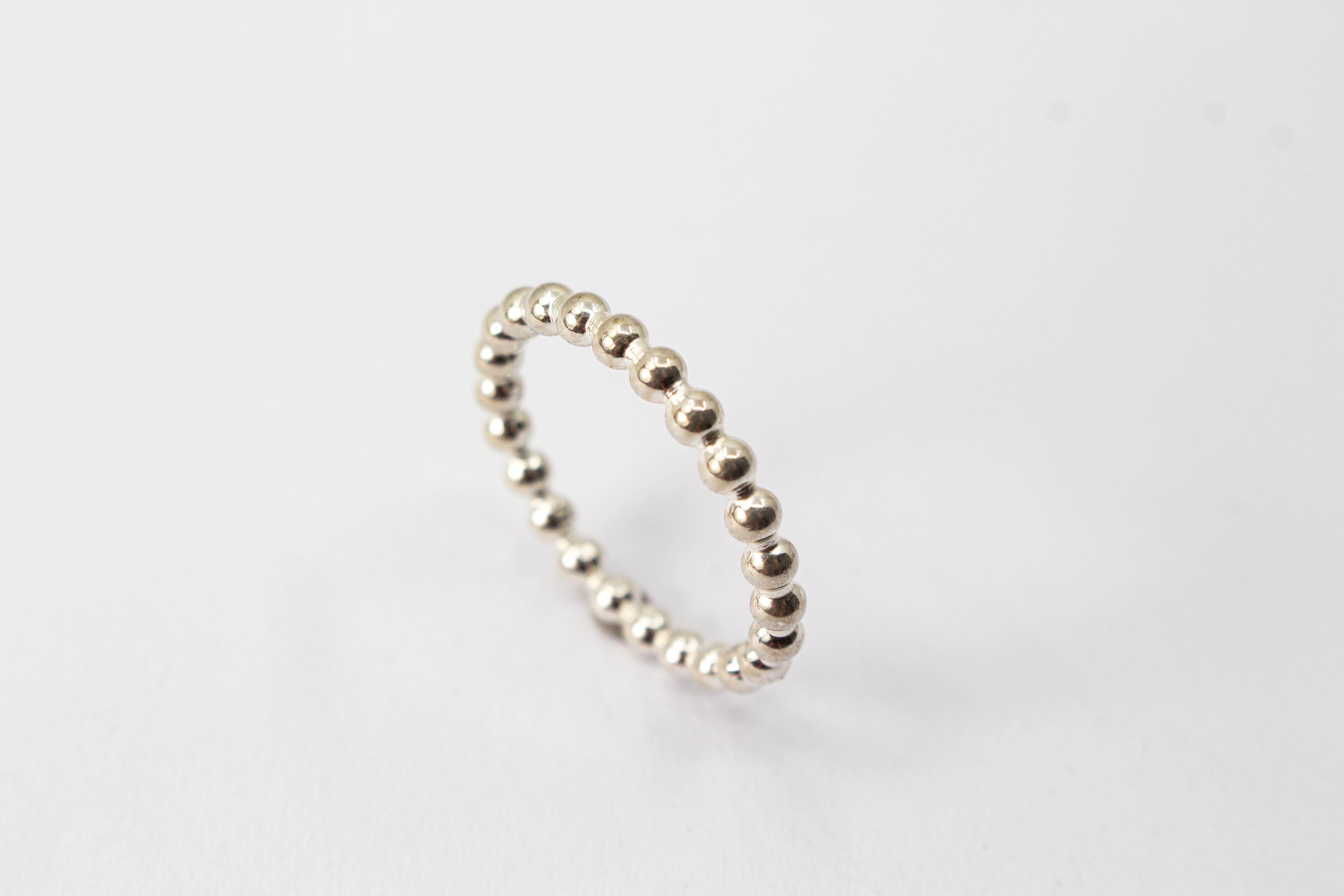 Handgefertigter Kugelring aus glänzendem 925 Sterlingsilber im filigranen Perldraht-Design – minimalistischer Stapelring aus der Goldschmiede Regina Kraus.