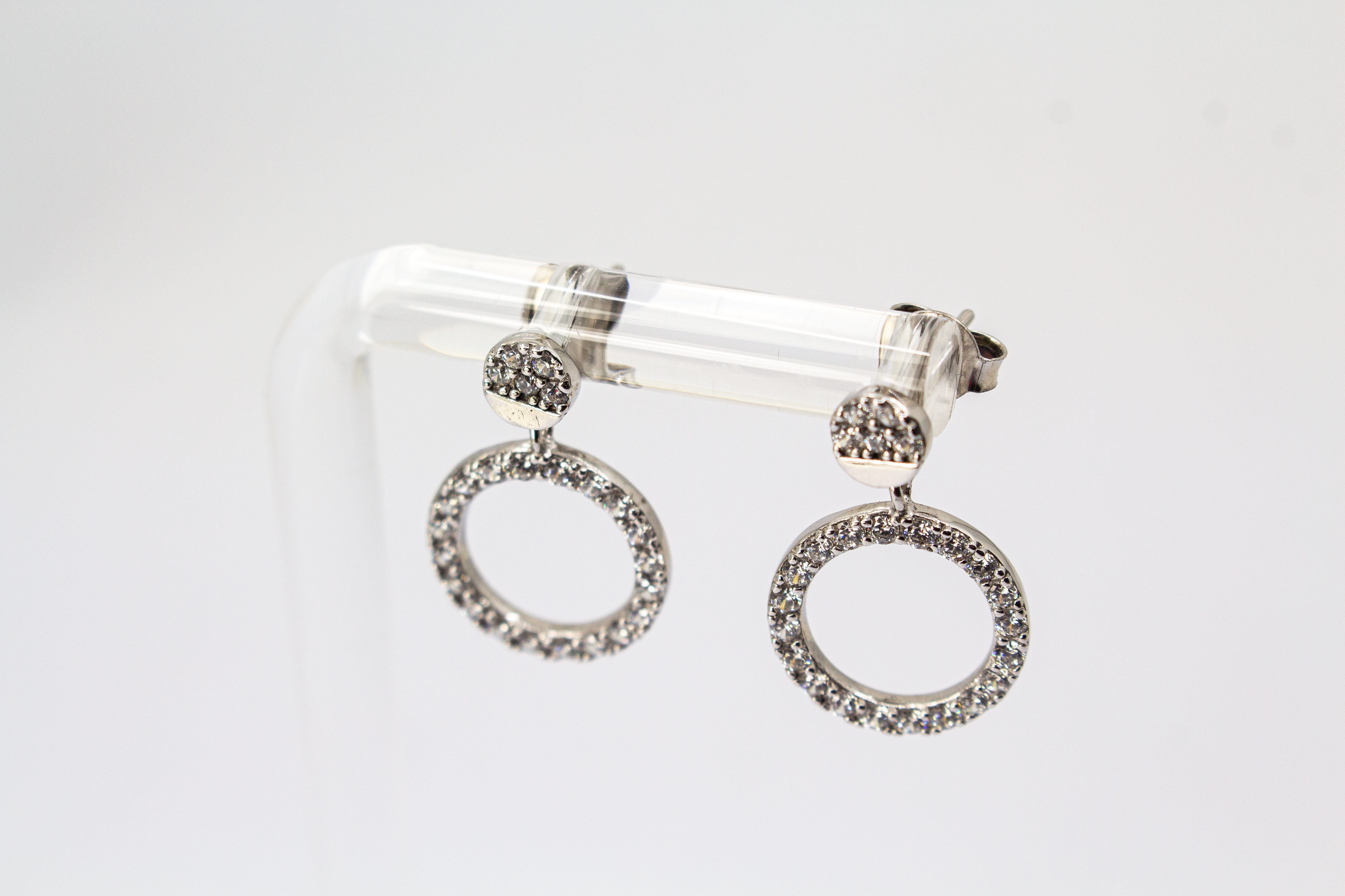 Elegante Ohrstecker aus rhodiniertem 925er Silber mit einem großen, rundum mit Zirkonia besetzten Kreis-Anhänger im Onlineshop von Goldschmiede Regina Kraus.