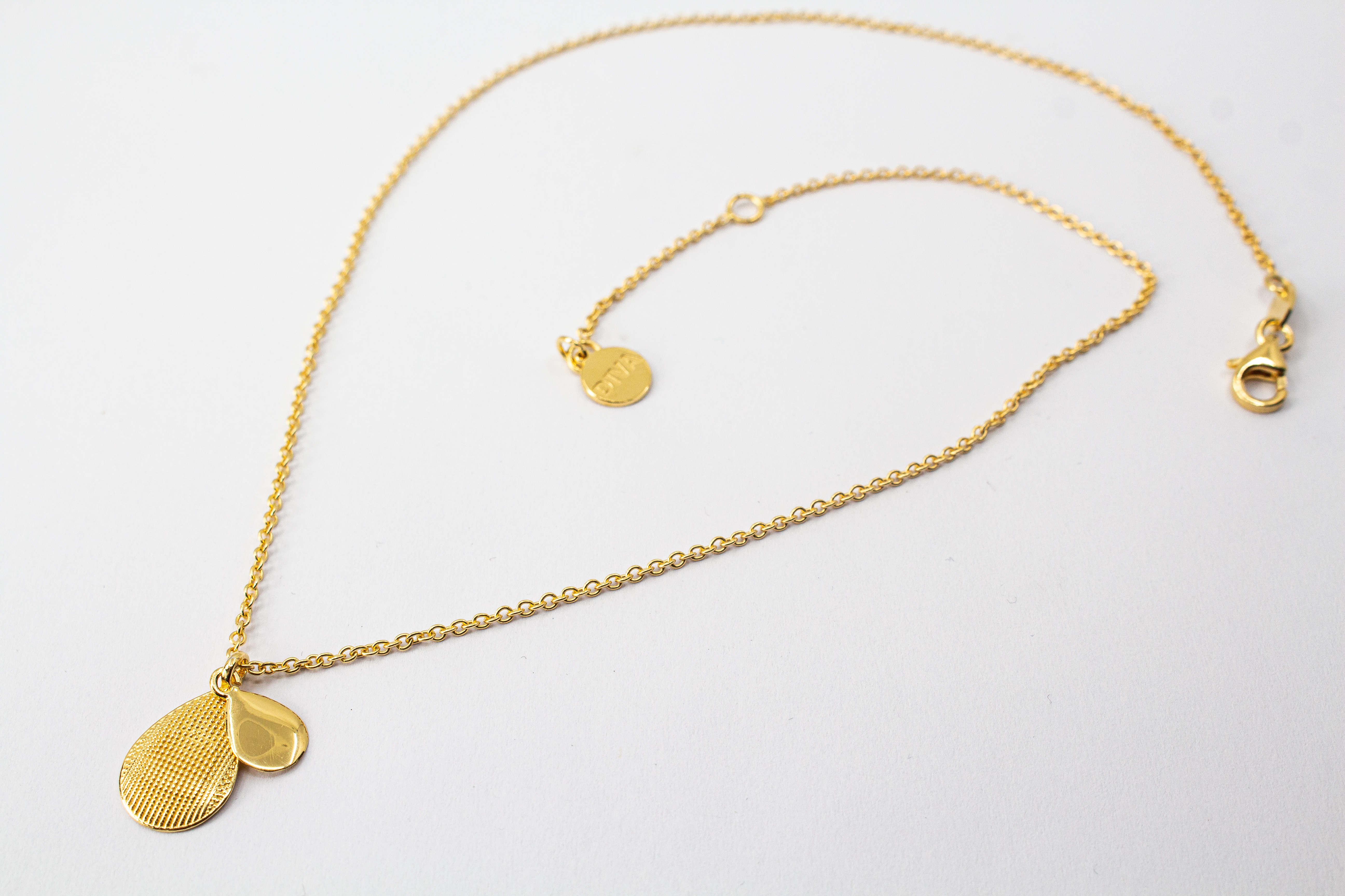 Italienische Design-Kette Cosmic Drop von Diva Gioielli: Anhänger aus zwei Tropfen in glänzendem und strukturiertem Gold-Finish, gefertigt aus vergoldetem 925er Sterlingsilber.