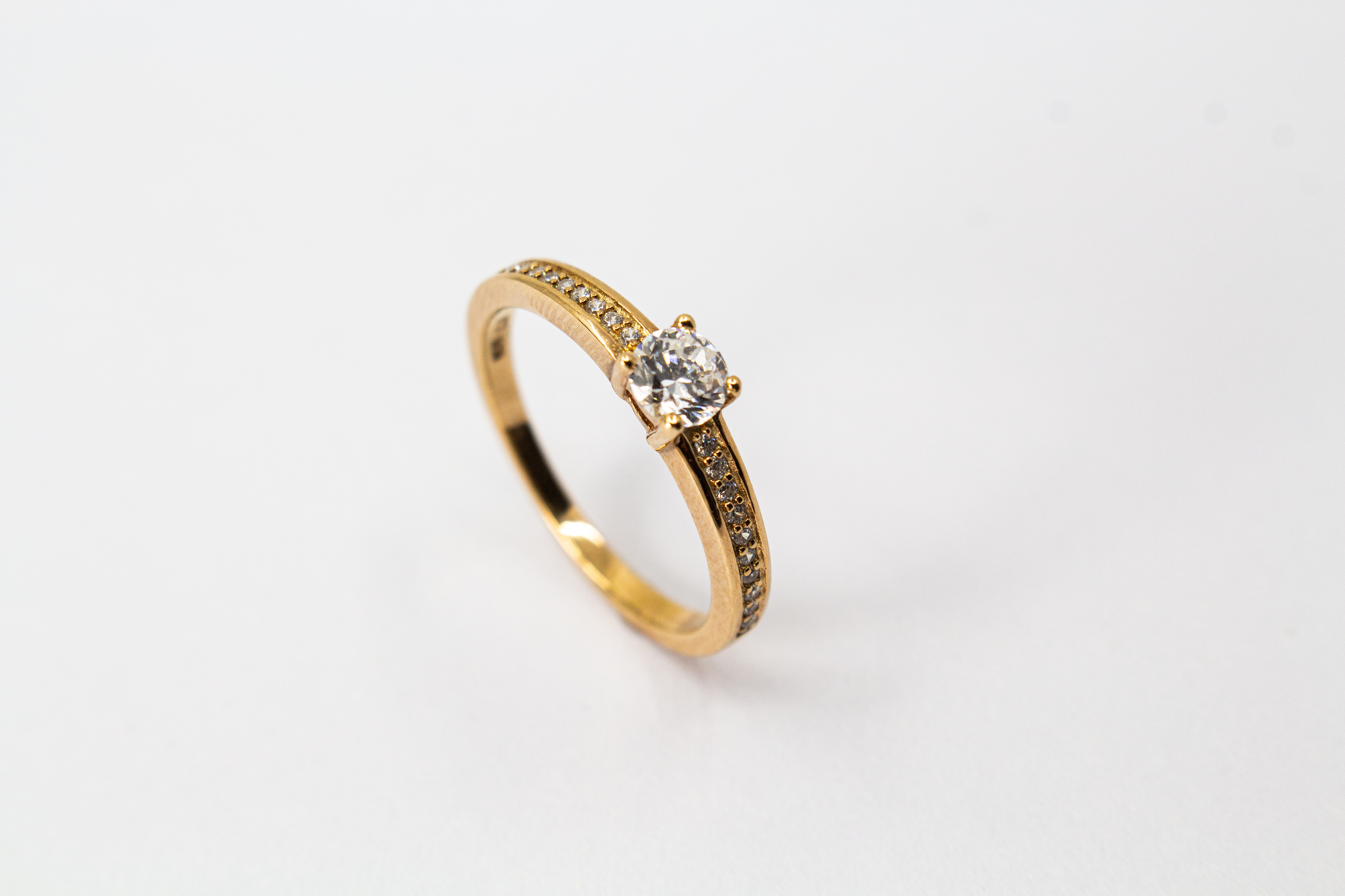 Eleganter Damenring aus rosévergoldetem 925 Sterling Silber mit einem großen, rund facettierten Zirkonia-Hauptstein in einer klassischen Vier-Krappenfassung und einer mit kleinen Zirkoniasteinen im Pavé-Stil besetzten Ringschiene aus dem Online-Shop der G