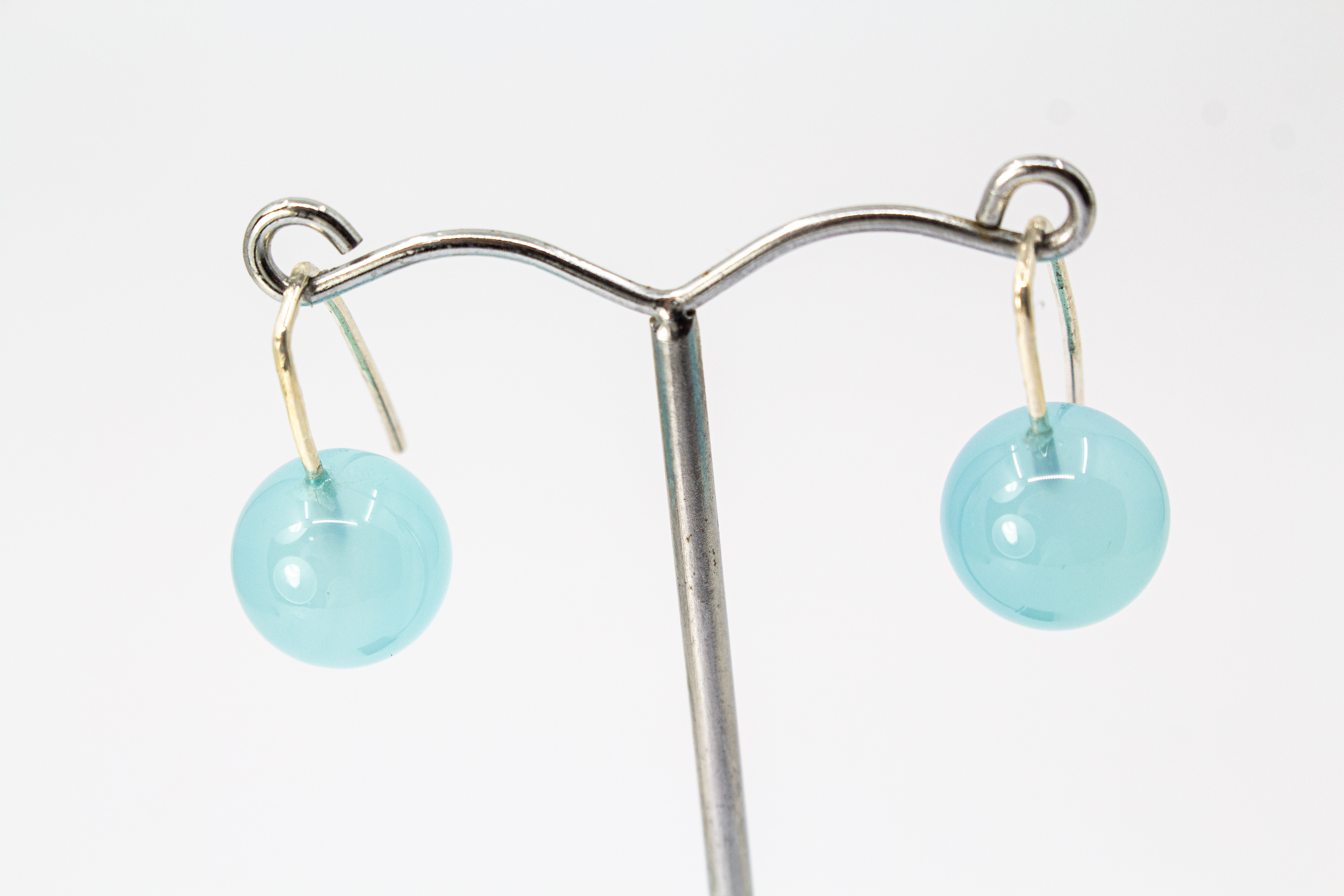 Minimalistische Ohrhänger aus feinen 925 Sterling Silberbügeln mit je einer glatten, hellblauen Chalcedon-Edelsteinkugel aus dem Online-Shop der Goldschmiede Regina Kraus
