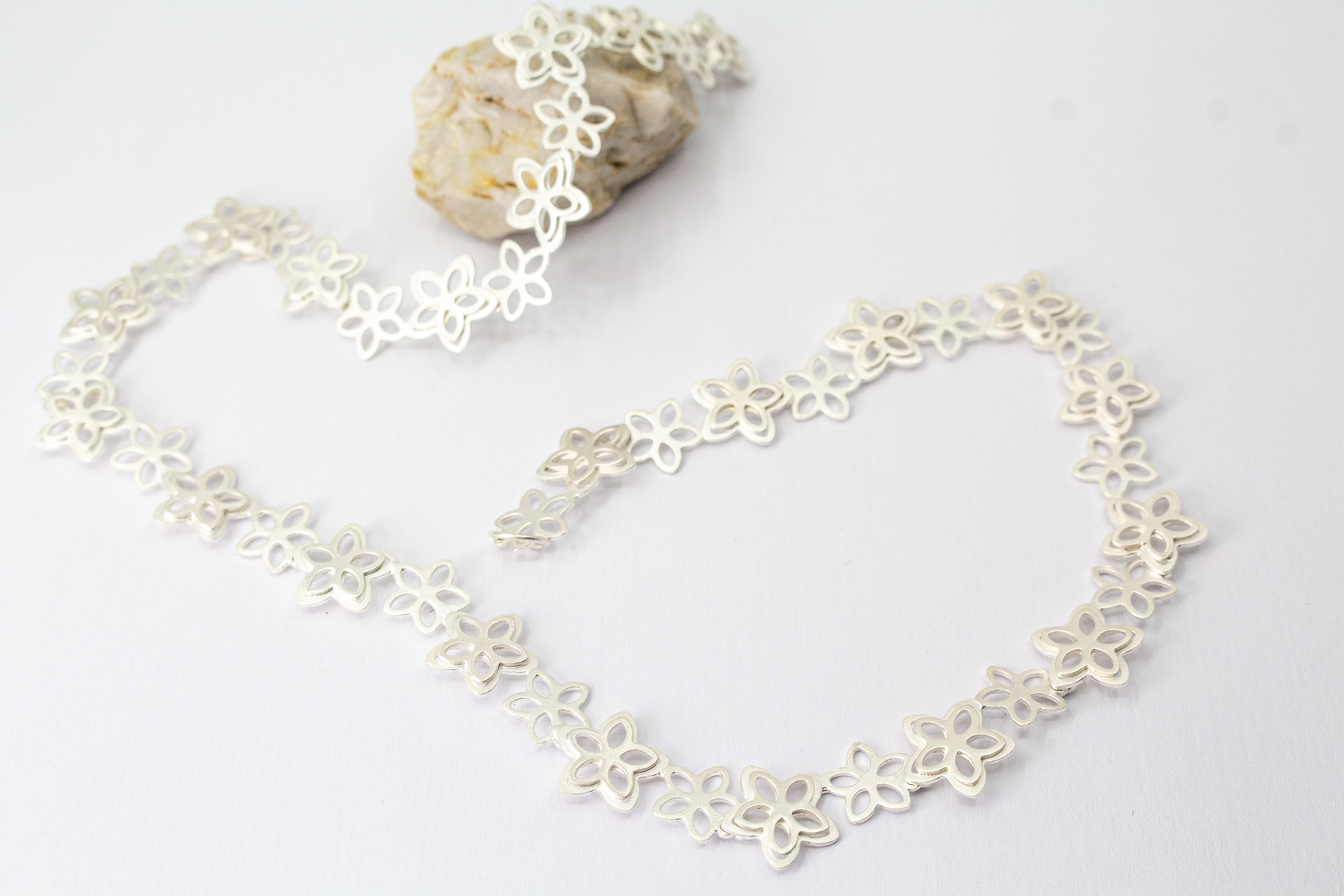 Filigranes Collier Rosalie aus der Goldschmiede Regina Kraus, gefertigt aus mattiertem 925er Sterling Silber mit aneinandergereihten, offenen Blüten-Motiven