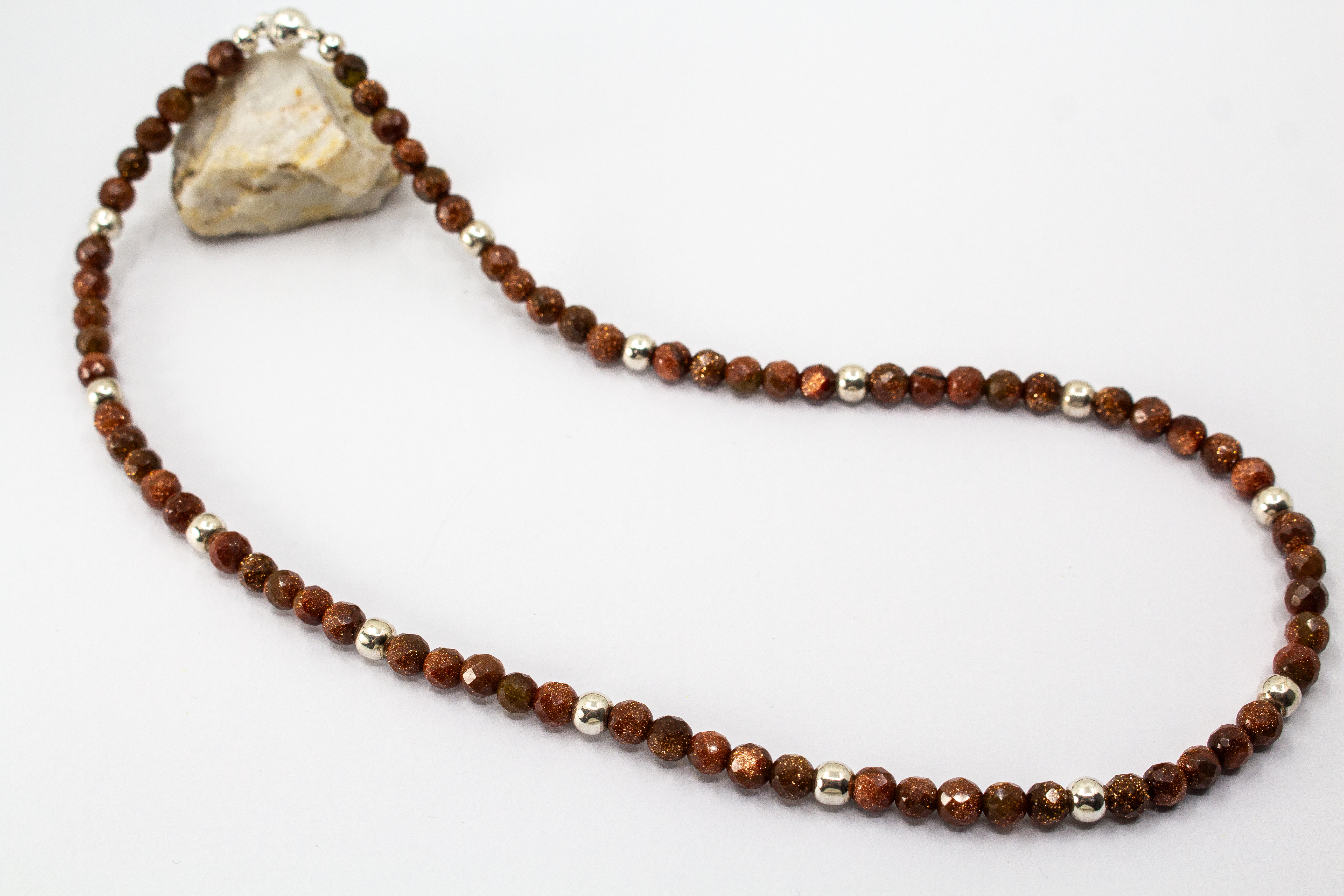 Collier „Goldflimmer“ aus facettiertem Goldfluss mit glänzenden Zwischenteilen aus 925er Sterlingsilber und funkelndem Goldschimmer.