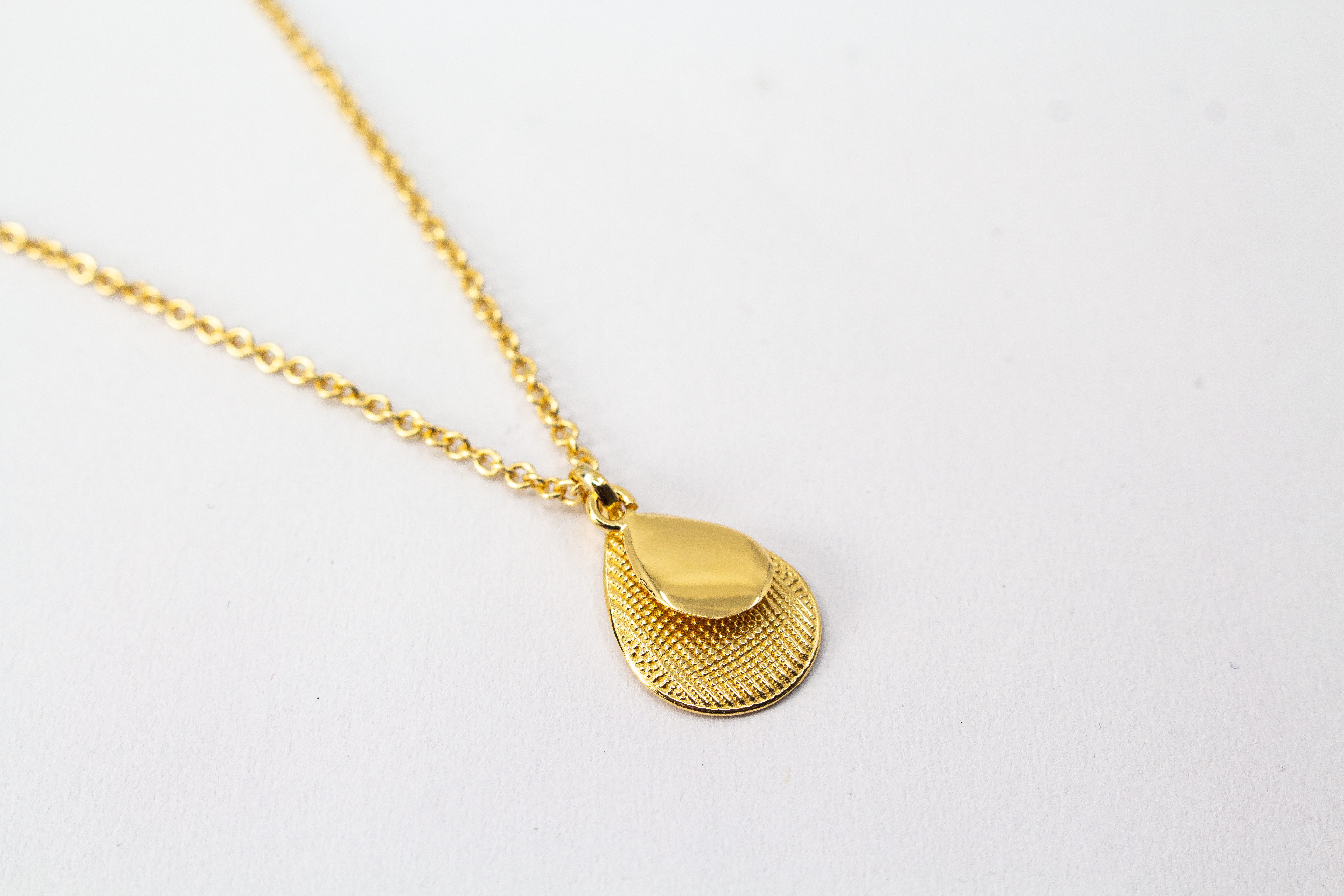 Italienische Design-Kette Cosmic Drop von Diva Gioielli: Anhänger aus zwei Tropfen in glänzendem und strukturiertem Gold-Finish, gefertigt aus vergoldetem 925er Sterlingsilber.