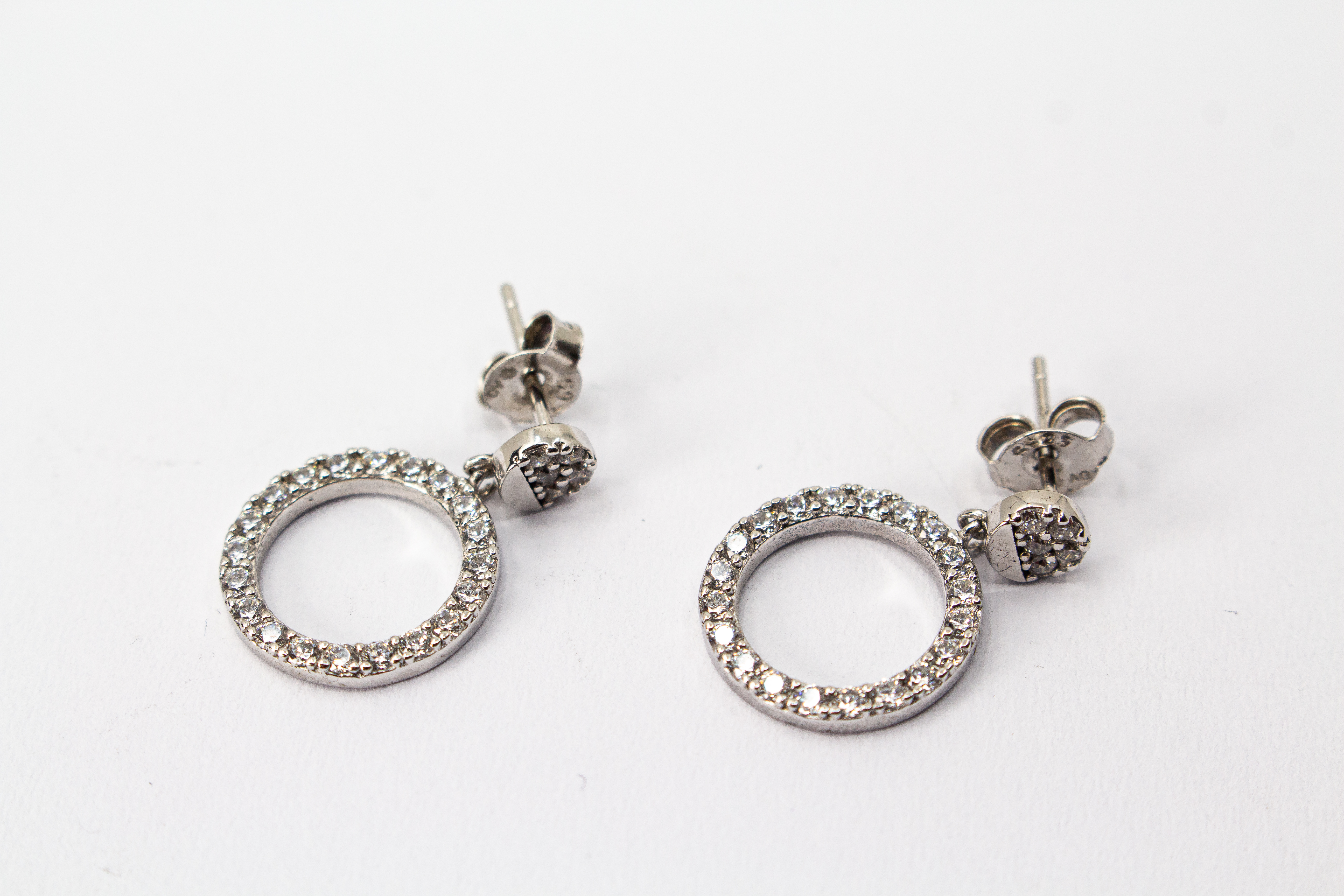 Elegante Ohrstecker aus rhodiniertem 925er Silber mit einem großen, rundum mit Zirkonia besetzten Kreis-Anhänger im Onlineshop von Goldschmiede Regina Kraus.