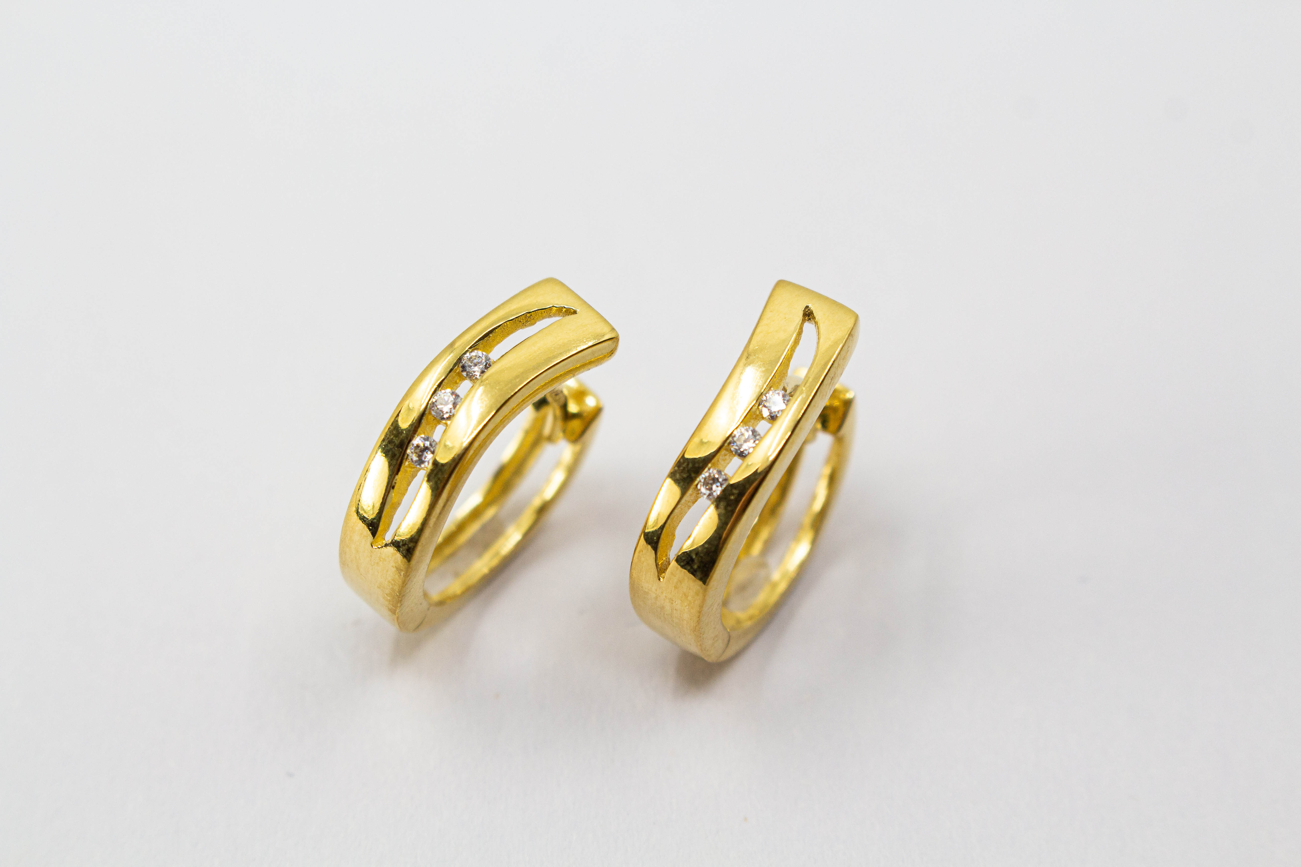 Elegante Creolen „Goldfunken“ aus 20 Mikron vergoldetem 925er Sterlingsilber mit funkelnden Zirkonia in geschwungener Form.