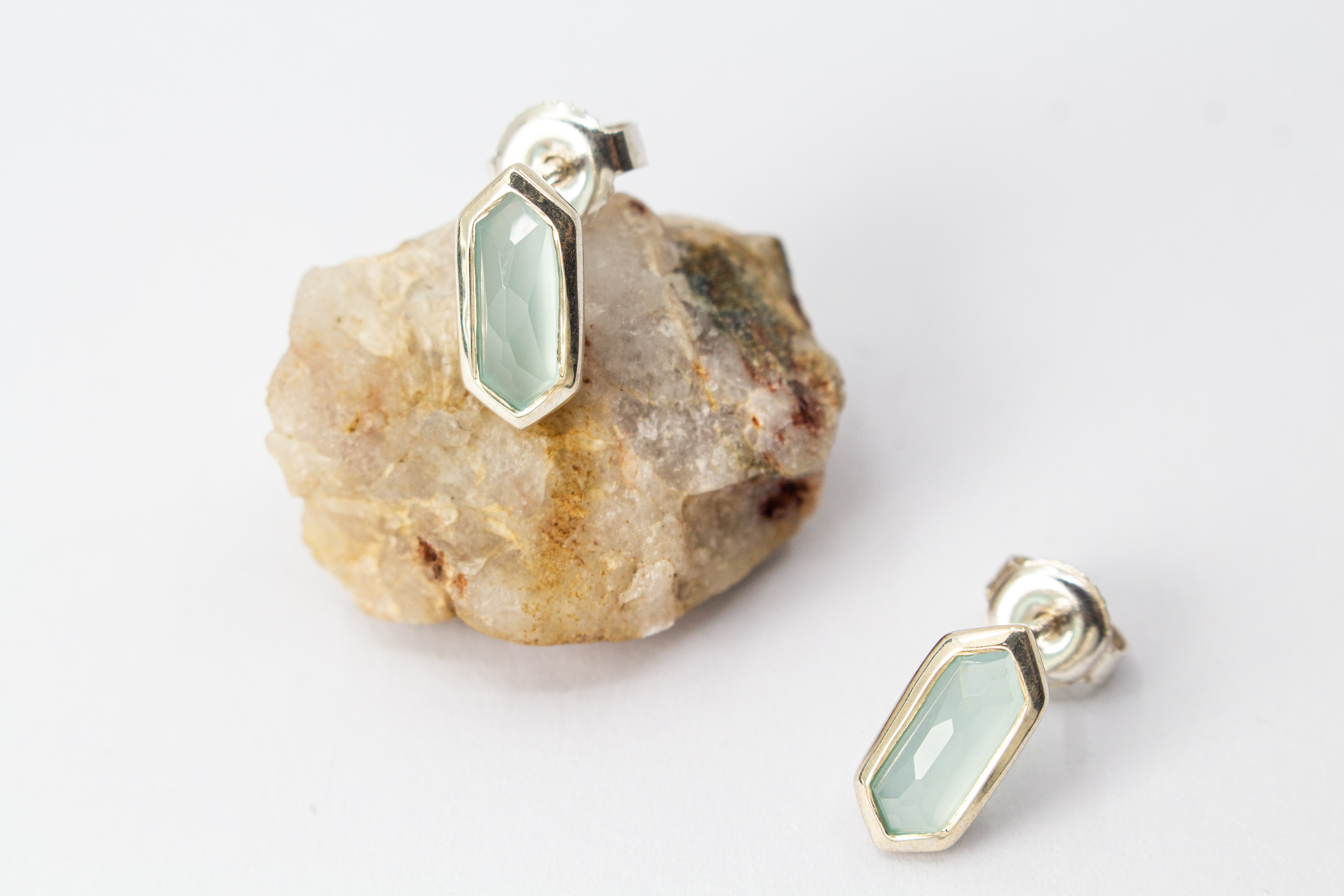 geometrische Ohrstecker aus glänzendem 925 Sterling Silber mit einem facettierten, sechseckigen Chalcedon-Edelstein in hellem Pastellblau aus dem Online-Shop der Goldschmiede Regina Kraus.