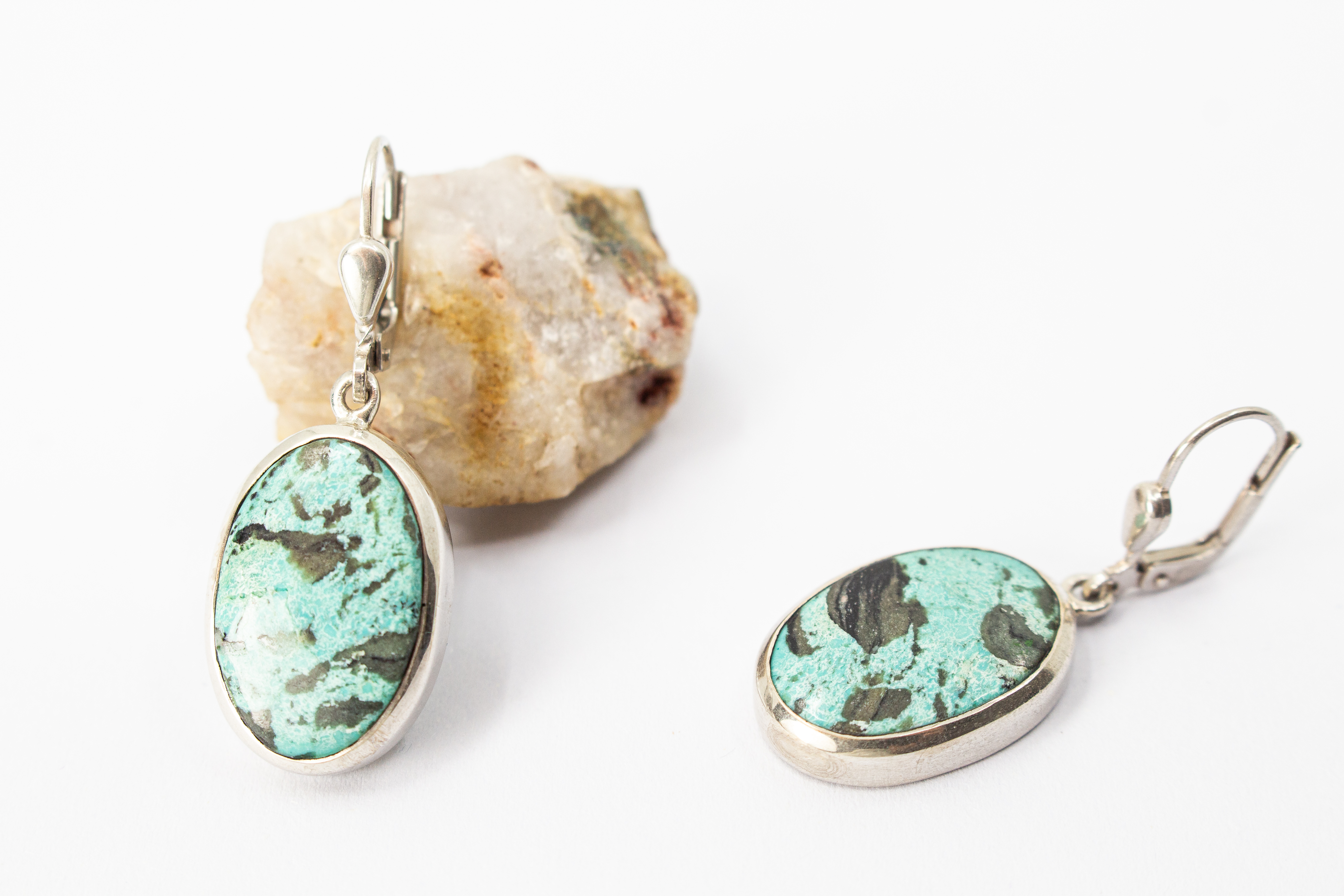 Elegante, hängende Ohrringe mit großen, ovalen Türkis-Edelsteinen in glatter Silberfassung an Klappbügeln (Brisuren) aus dem Online-Shop der Goldschmiede Regina Kraus.