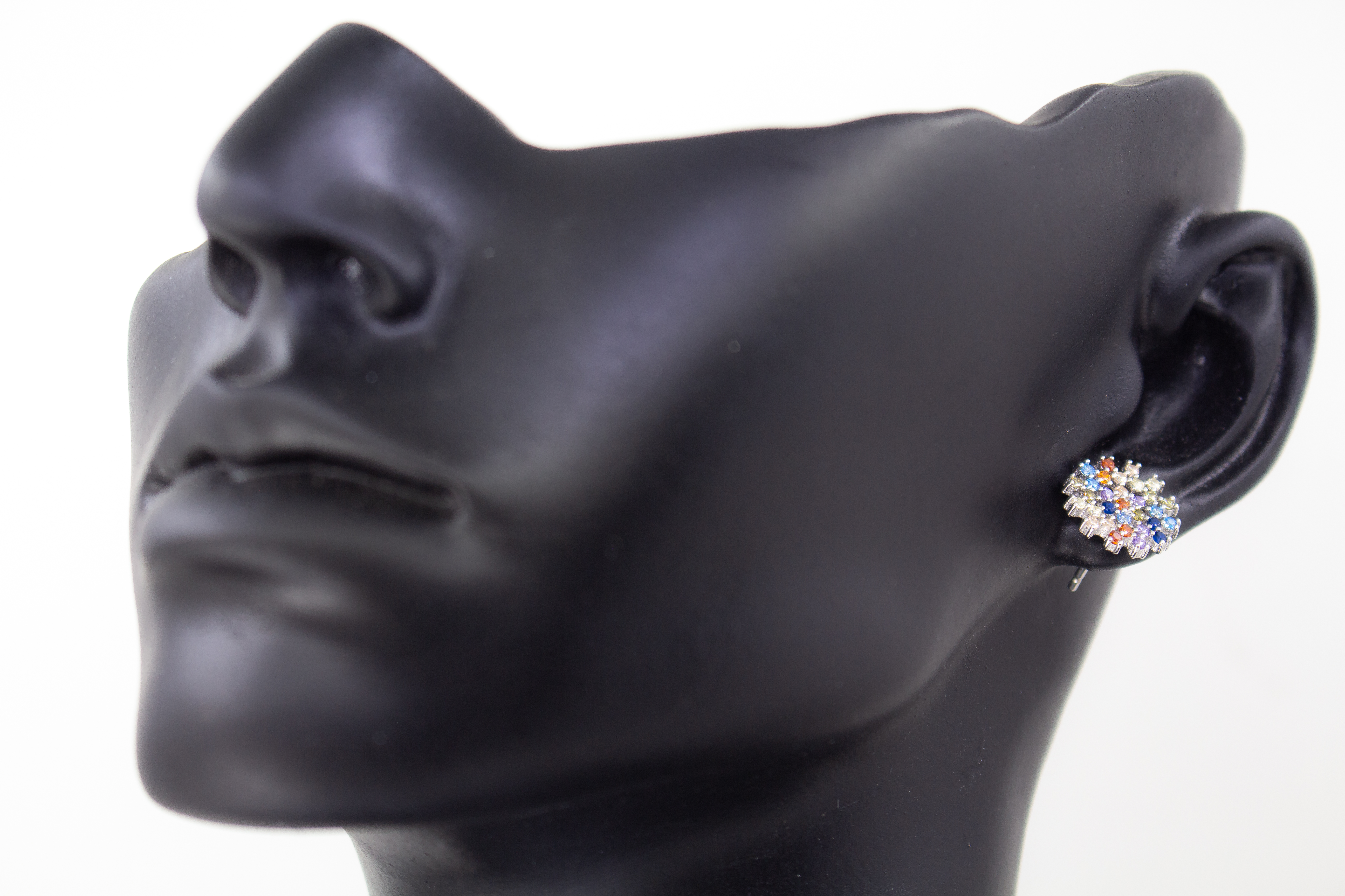 Die filigranen 925er Silber-Ohrstecker „Fleur de Lumière“ aus der Goldschmiede Regina Kraus, präsentiert auf einem transparenten Schmuckständer. Das florale Design erinnert an eine funkelnde Lichtblume und ist kunstvoll mit kleinen, bunt strahlenden Zirk