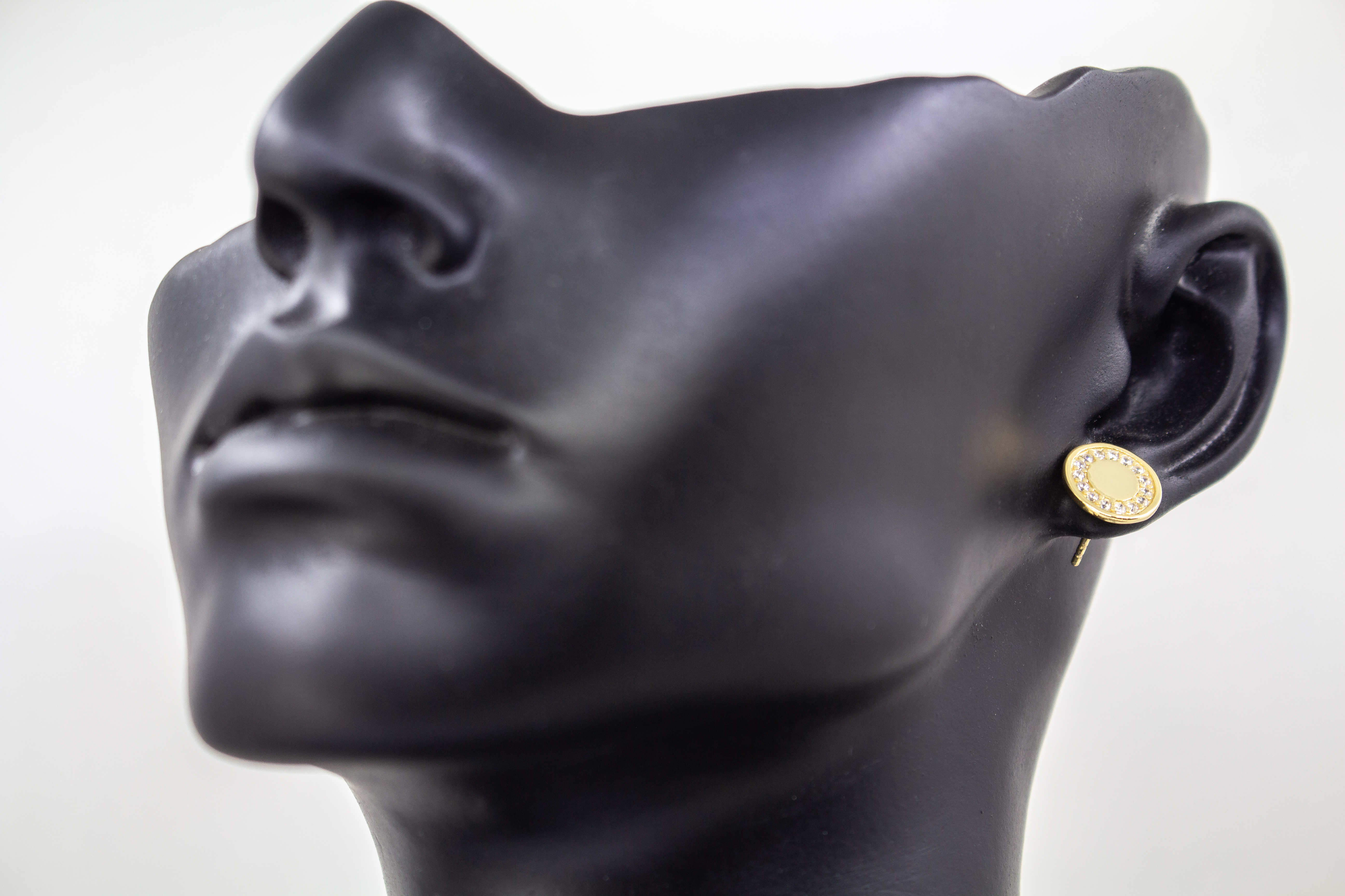Runde, vergoldete Ohrstecker aus 925er Silber mit einer glatten Innenfläche und einem äußeren Kranz aus funkelnden Zirkoniasteinen im Onlineshop von Goldschmiede Regina Kraus.