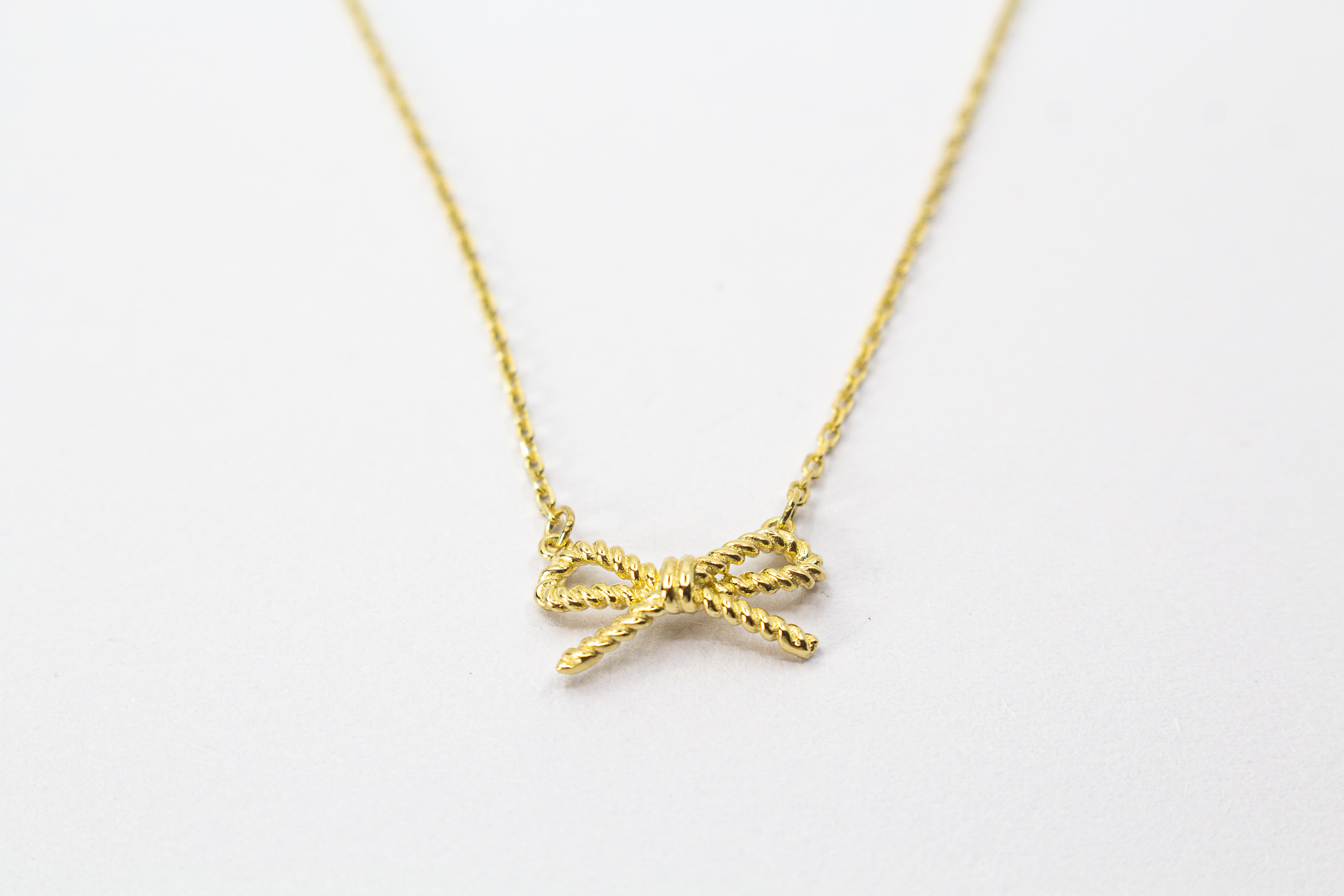 Collier „Schleifenzauber“ aus vergoldetem 925er Sterlingsilber mit filigranem Schleifenanhänger in elegantem, zeitlosem Design.