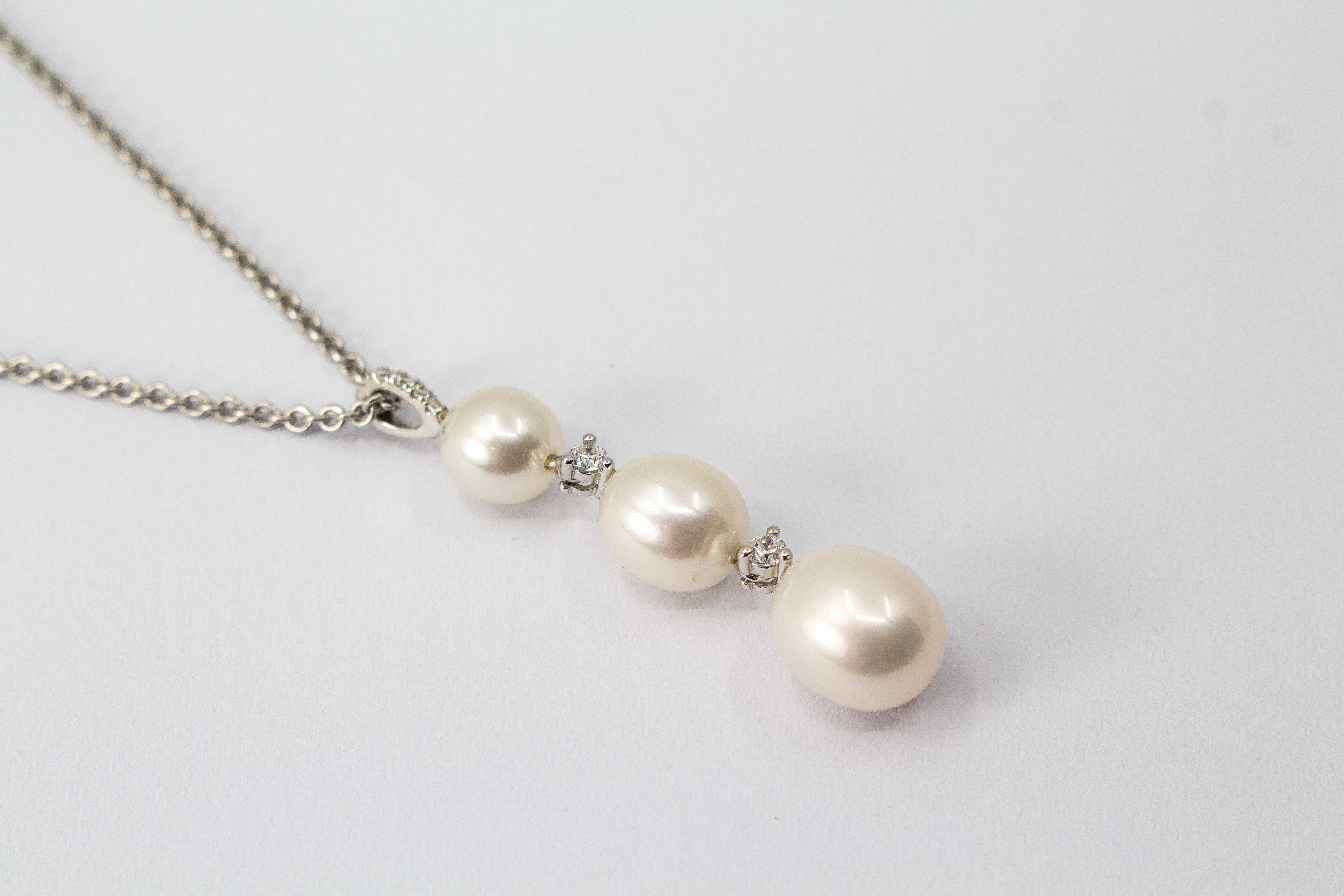 Hochwertiges Collier aus rhodiniertem 925er Sterlingsilber mit drei hängenden Süßwasserzuchtperlen und funkelnden Zirkonia-Zwischenelementen, Schmuckdesign von Regina Kraus