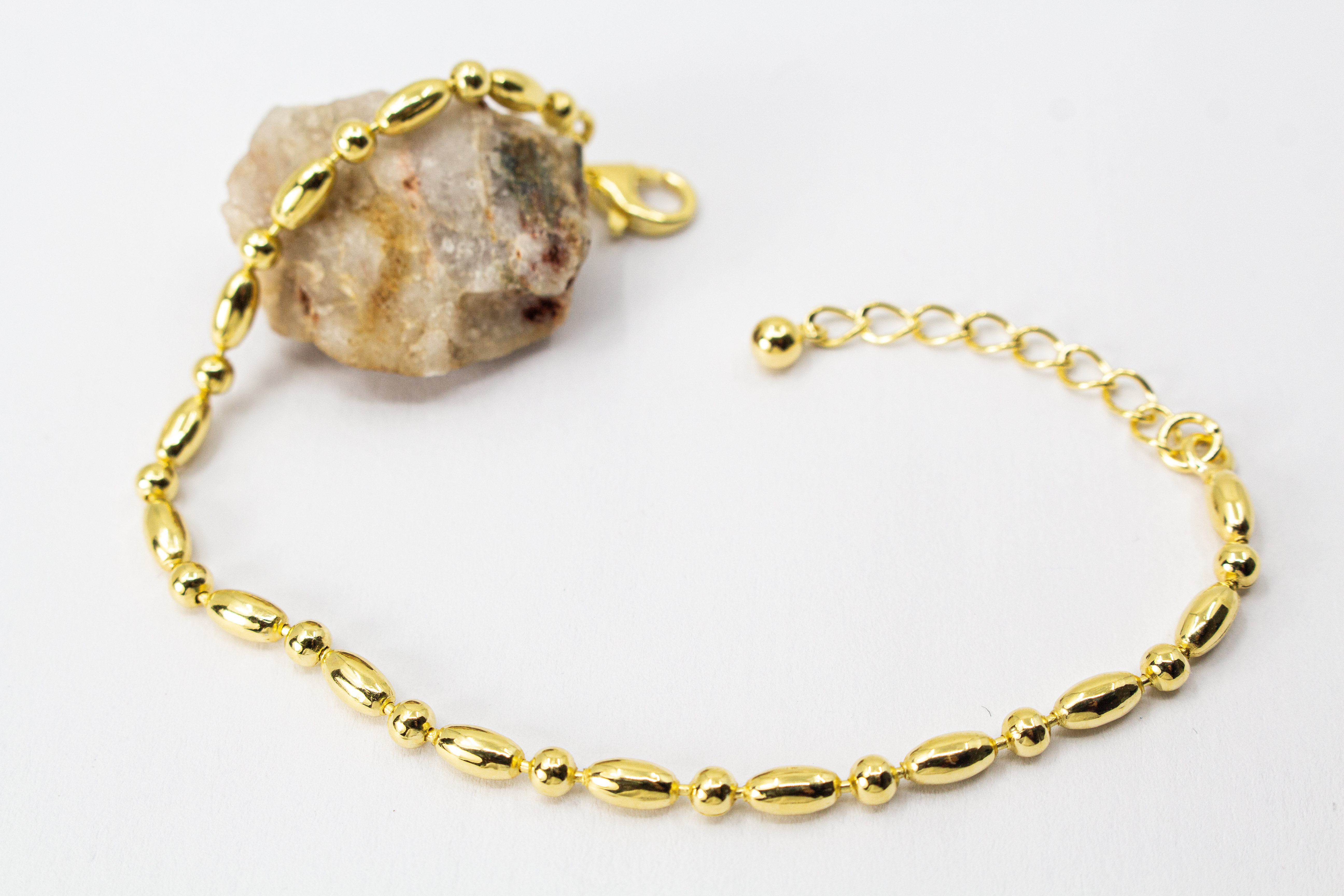 Filigranes, hochwertig vergoldetes Silberarmband (925er Silber, 20 Mikron Vergoldung) mit einem wechselnden Muster aus glänzenden Oliven- und Kugel-Elementen sowie Karabinerverschluss, erhältlich im Onlineshop der Goldschmiede Regina Kraus.