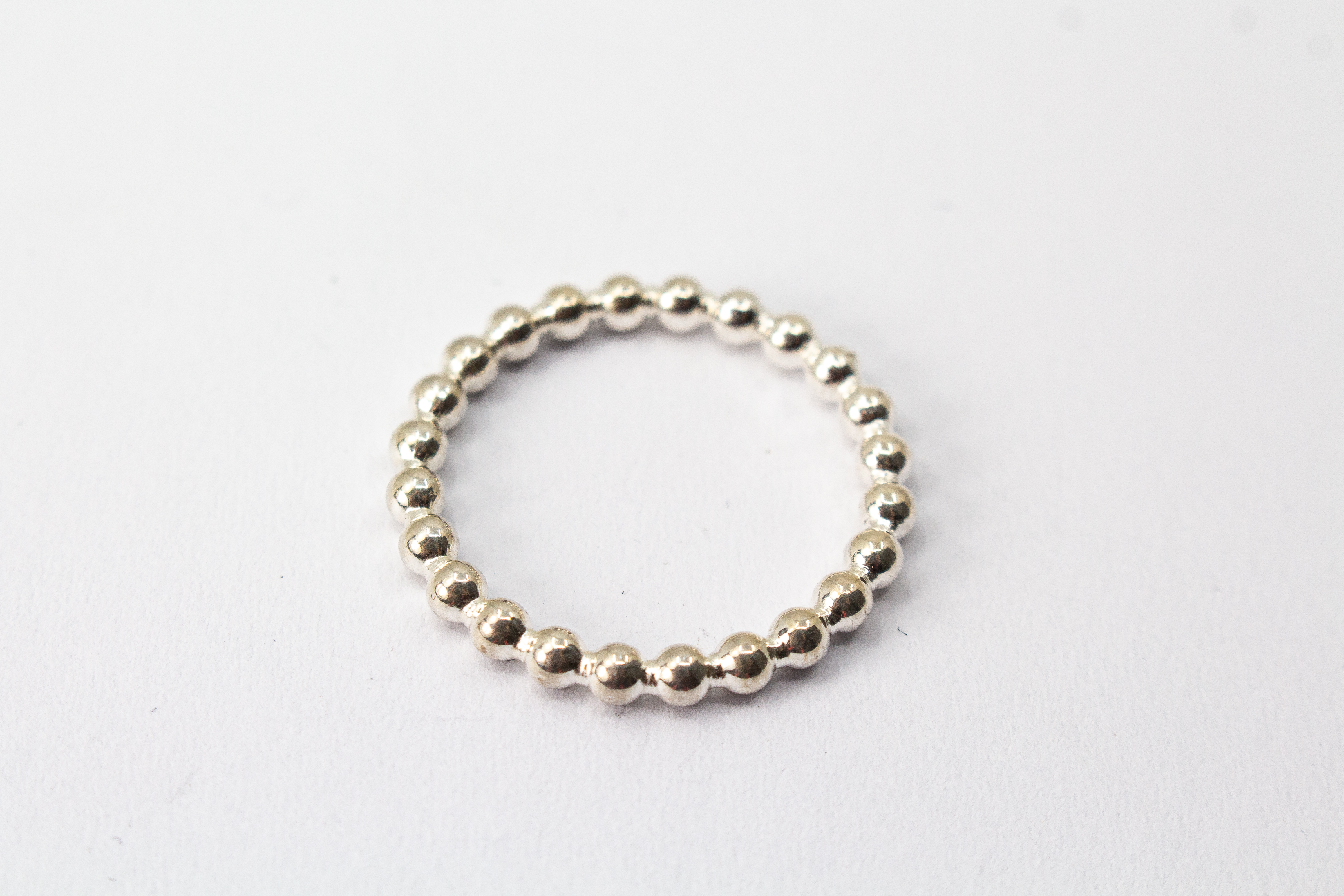 Handgefertigter Kugelring aus glänzendem 925 Sterlingsilber im filigranen Perldraht-Design – minimalistischer Stapelring aus der Goldschmiede Regina Kraus.