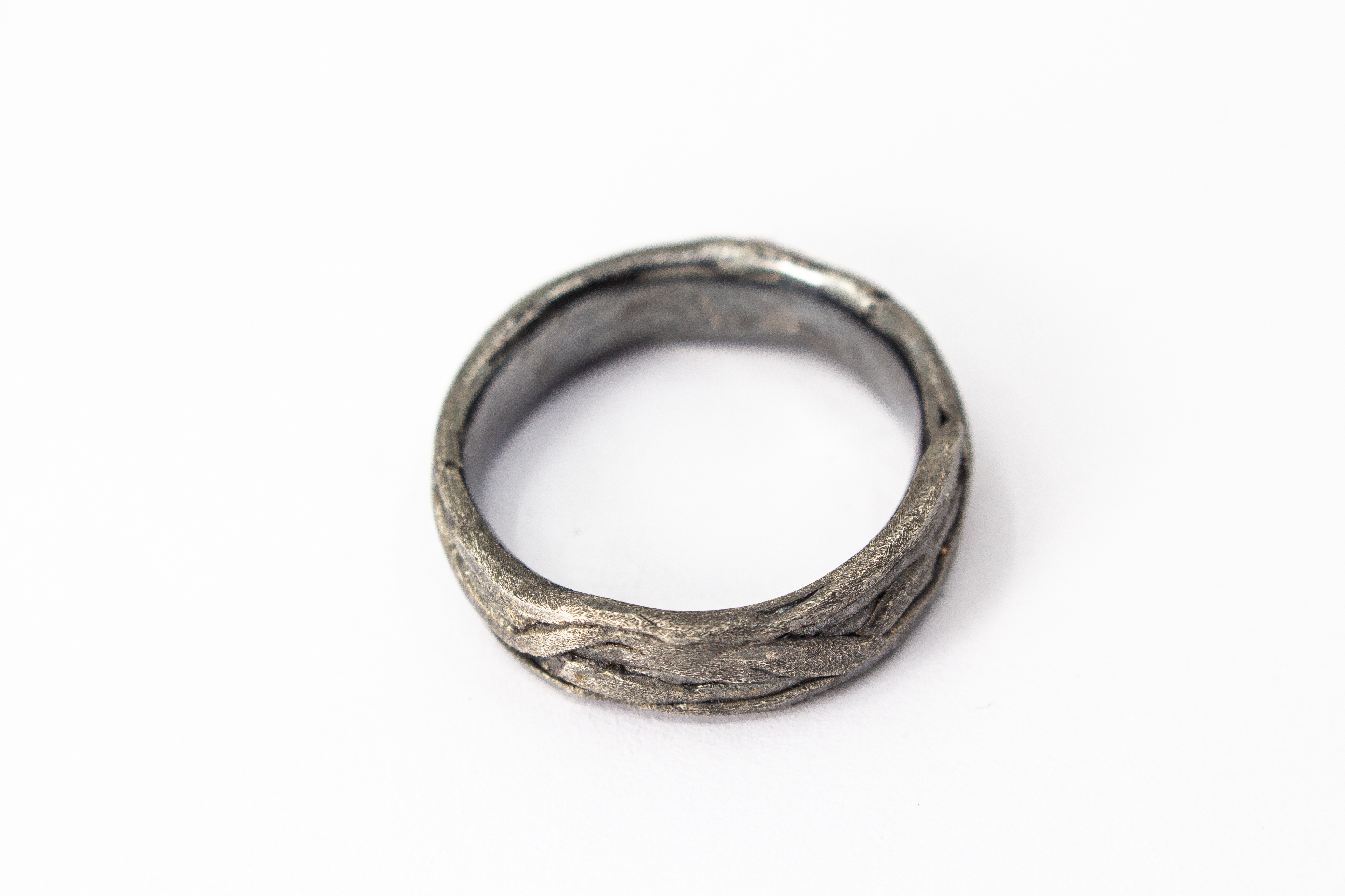 Markanter, strukturierter Bandring aus dunkel geschwärztem und oxidiertem 925 Sterlingsilber mit einer organisch geflochtenen Oberfläche im Ast- oder Rinden-Design aus dem Online-Shop der Goldschmiede Regina Kraus.