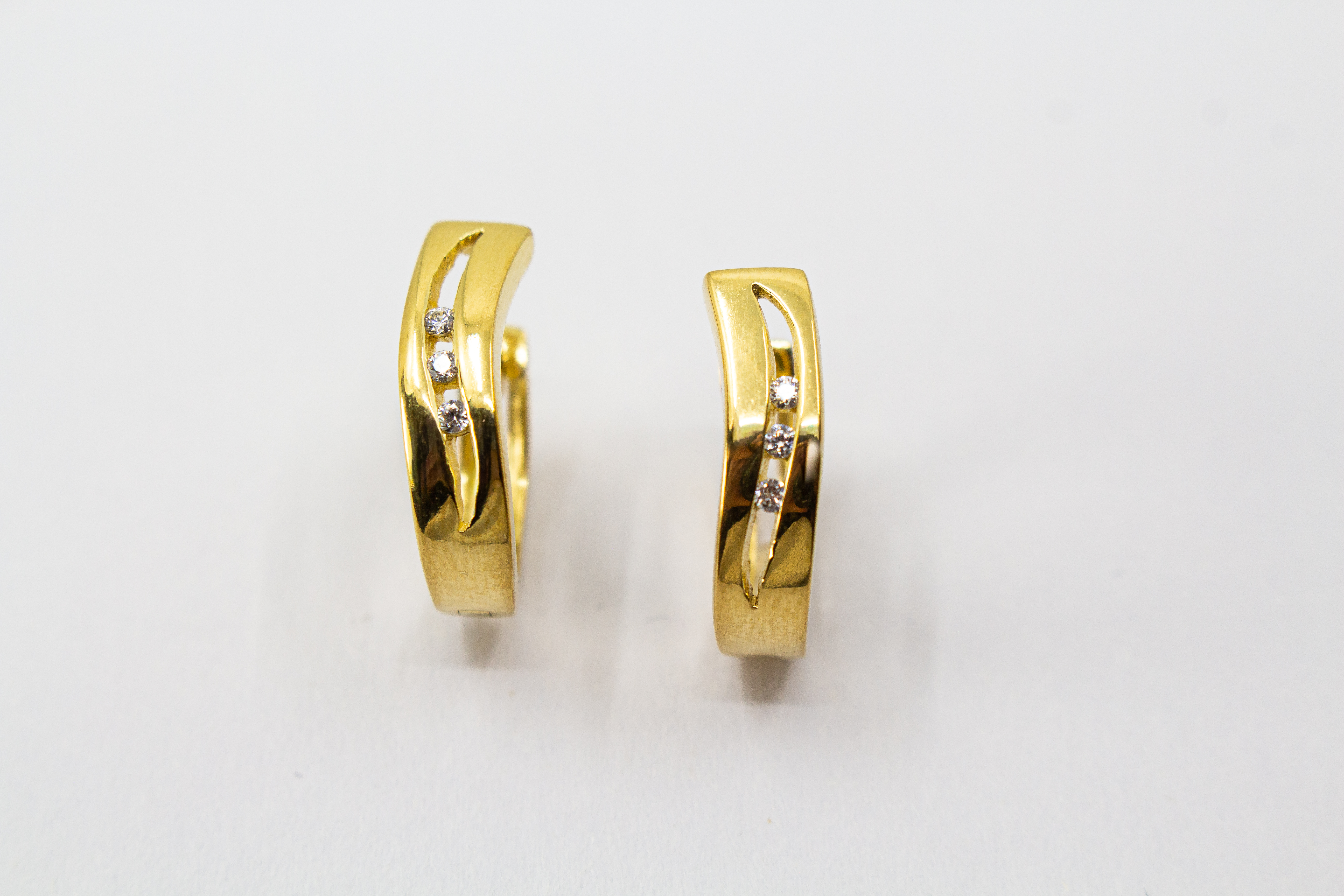 Elegante Creolen „Goldfunken“ aus 20 Mikron vergoldetem 925er Sterlingsilber mit funkelnden Zirkonia in geschwungener Form.