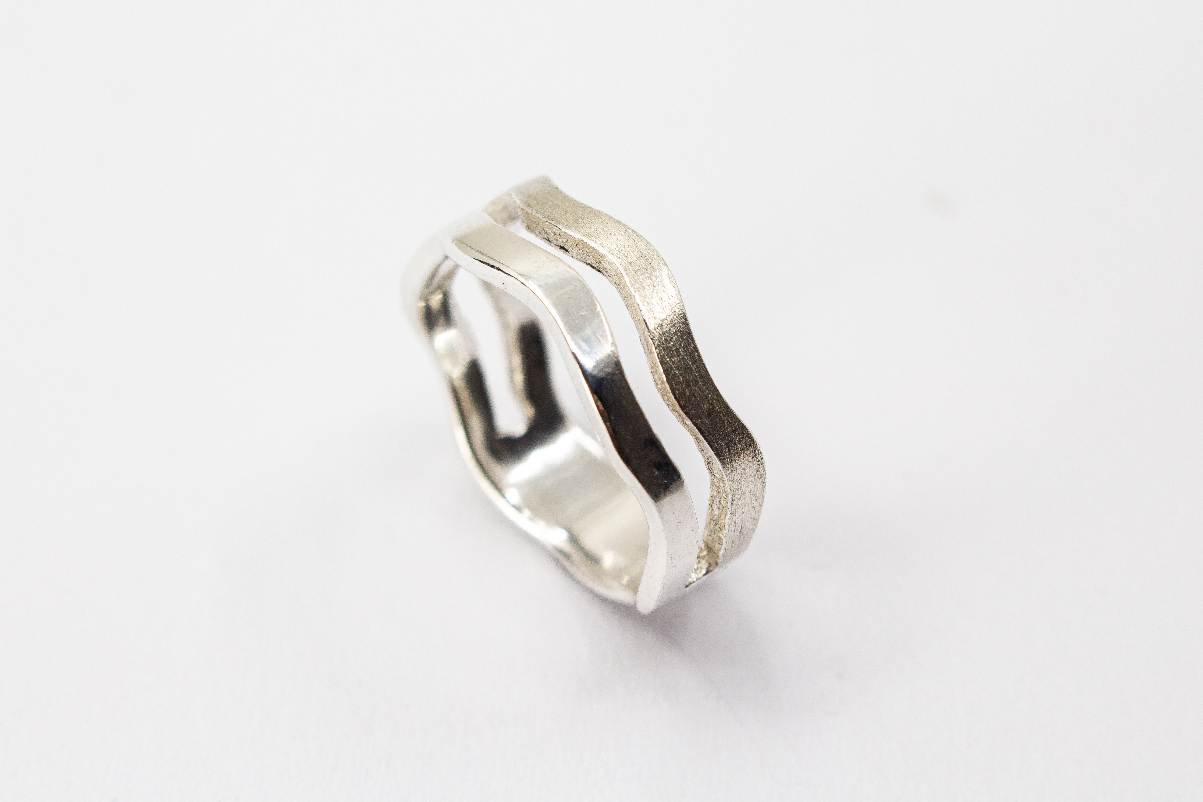 Ausgefallener Ring aus 925er Silber in zweireihiger Wellenoptik mit einer eismattierten Struktur-Schiene und einer glänzend polierten Schiene im Onlineshop von Goldschmiede Regina Kraus.