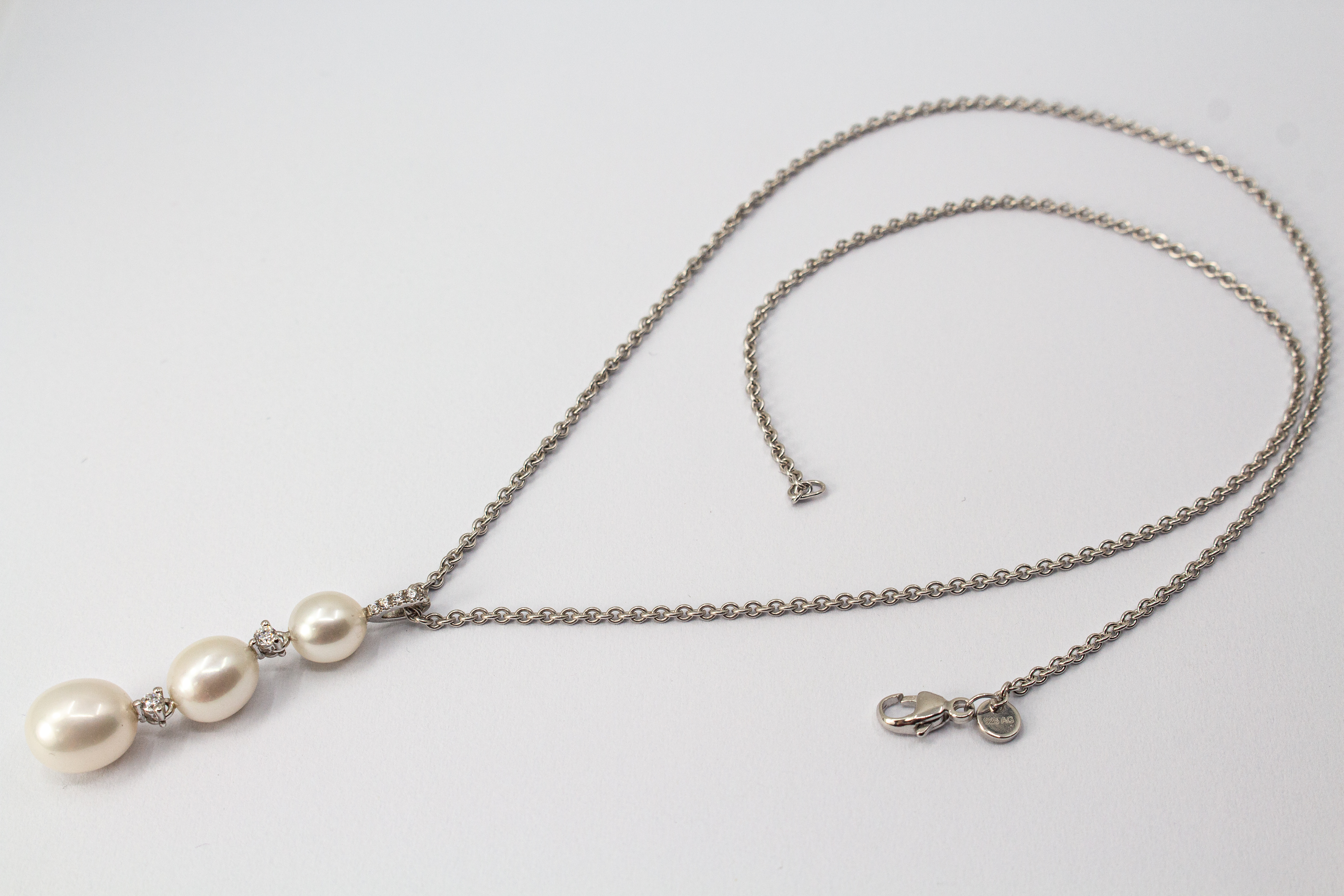 Hochwertiges Collier aus rhodiniertem 925er Sterlingsilber mit drei hängenden Süßwasserzuchtperlen und funkelnden Zirkonia-Zwischenelementen, Schmuckdesign von Regina Kraus