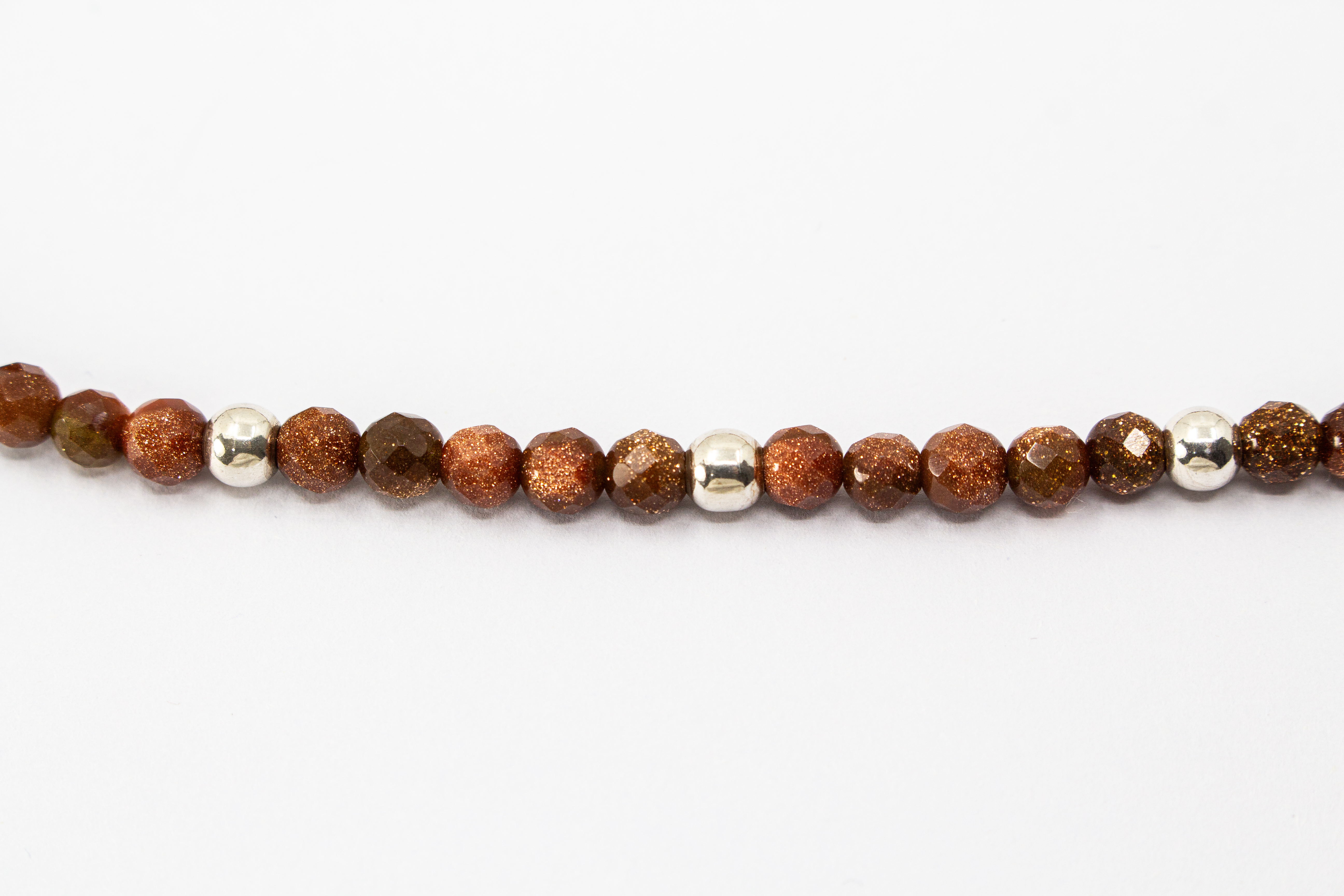 Collier „Goldflimmer“ aus facettiertem Goldfluss mit glänzenden Zwischenteilen aus 925er Sterlingsilber und funkelndem Goldschimmer.