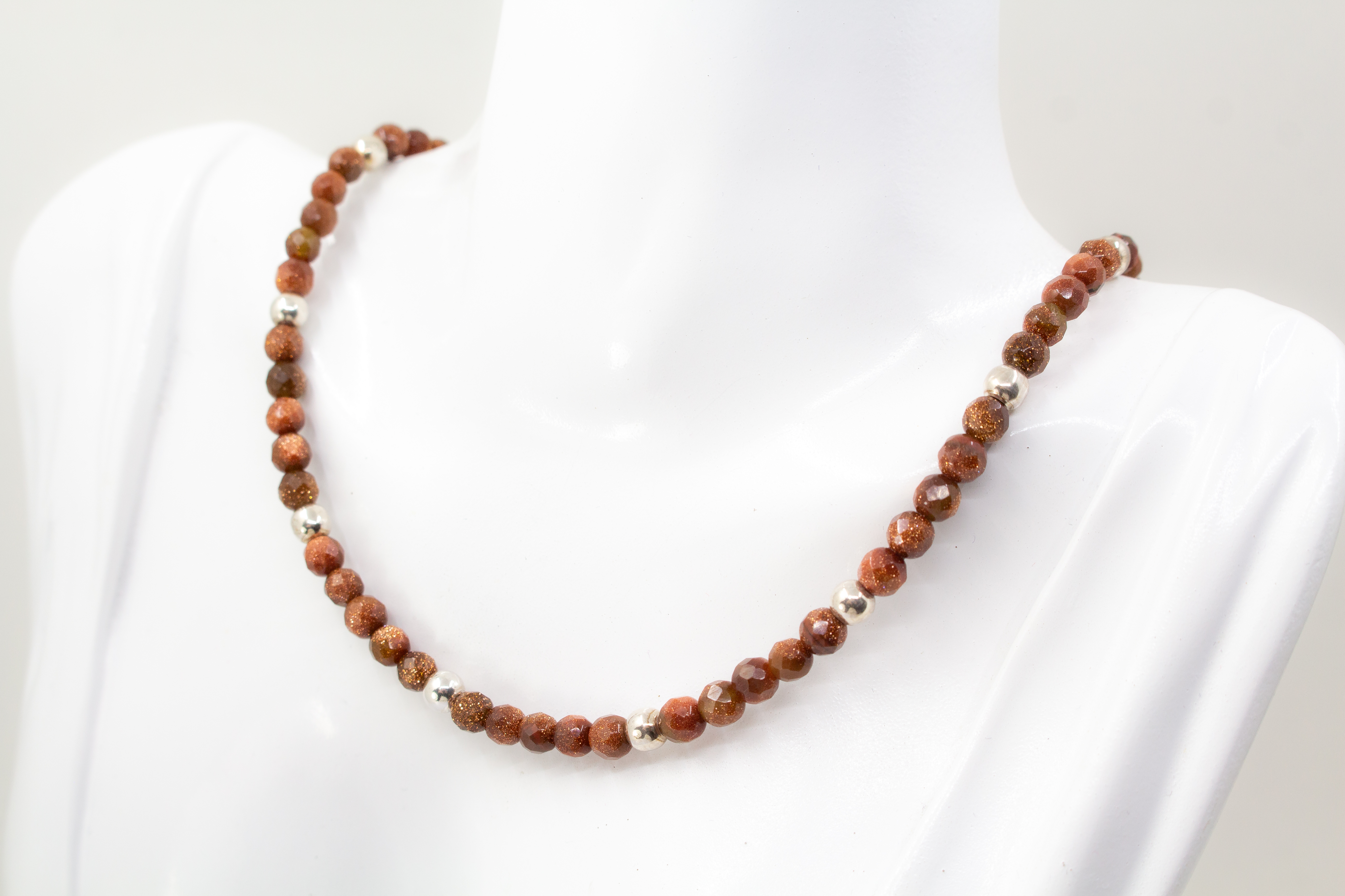 Collier „Goldflimmer“ aus facettiertem Goldfluss mit glänzenden Zwischenteilen aus 925er Sterlingsilber und funkelndem Goldschimmer.