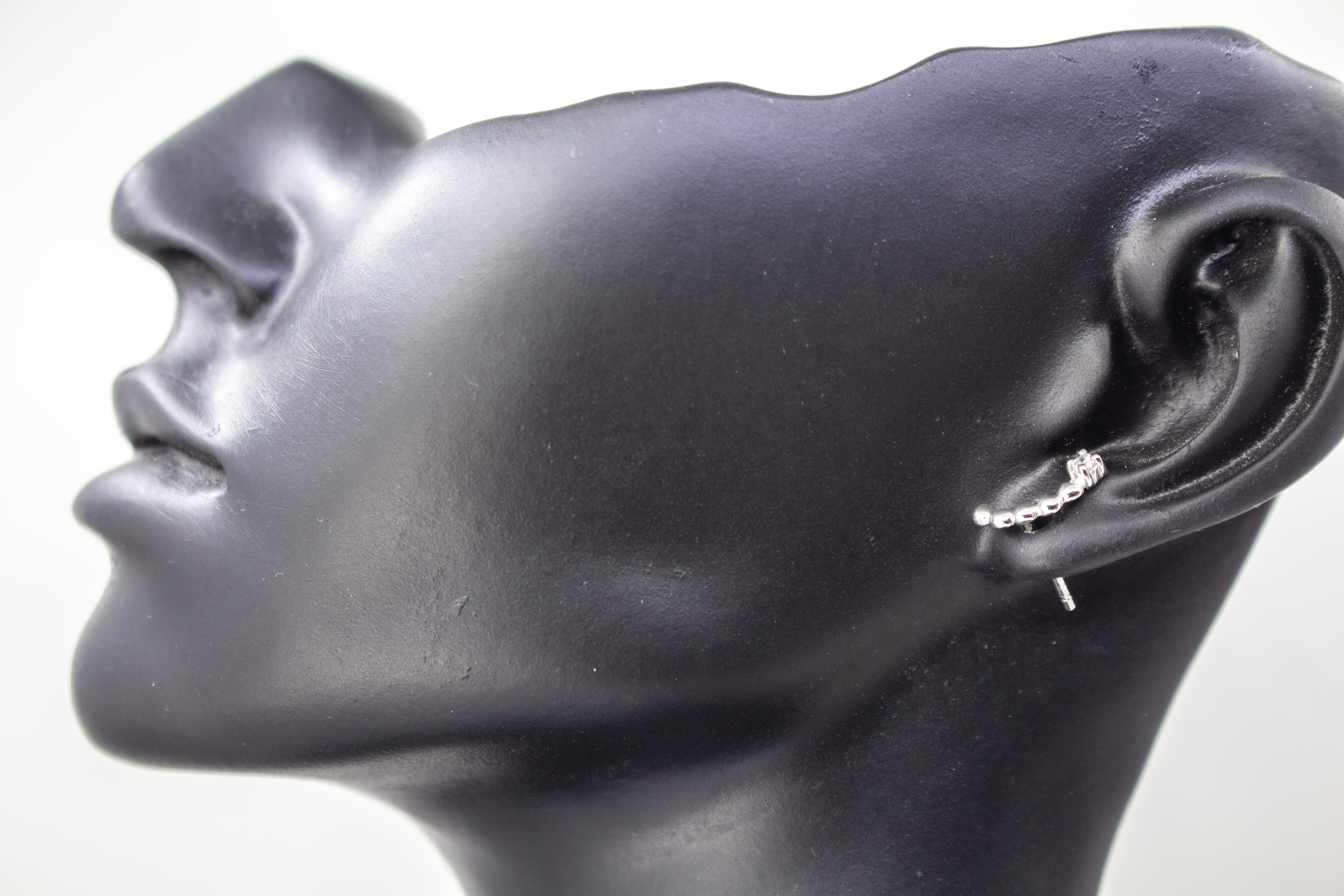 Moderne Ohrstecker aus rhodiniertem 925er Silber mit einem geschwungenen Bogen aus feinen Silberkugeln und funkelnden Zirkoniasteinen im Onlineshop von Goldschmiede Regina Kraus.