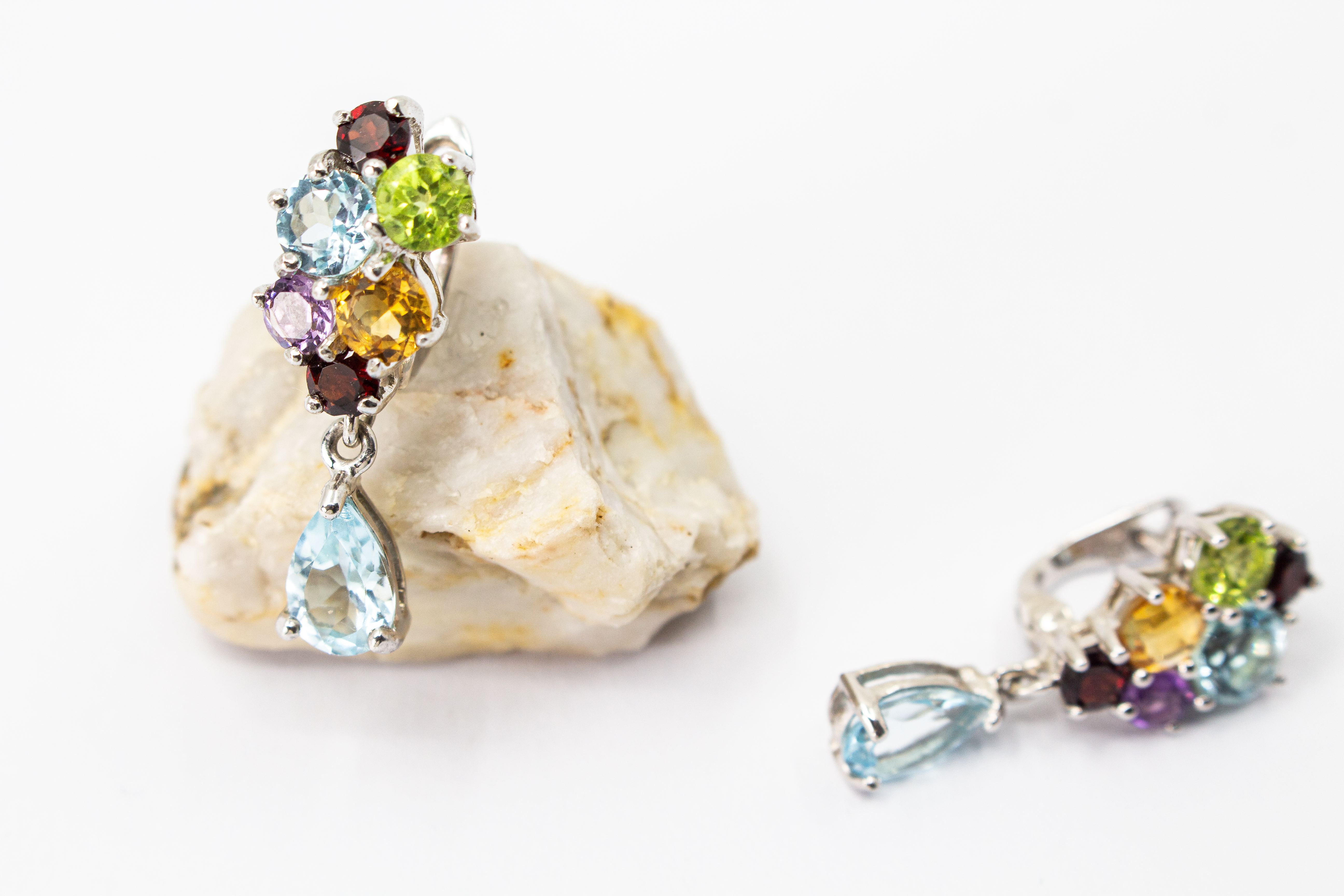 Elegante Multicolor-Edelstein-Ohrhänger aus rhodiniertem 925 Silber von der Goldschmiede Regina Kraus. Die detailreichen Ohrringe zeigen ein farbenfrohes Cluster aus rund facettierten Steinen wie Amethyst, Peridot, Citrin und Granat, gefolgt von einem bew