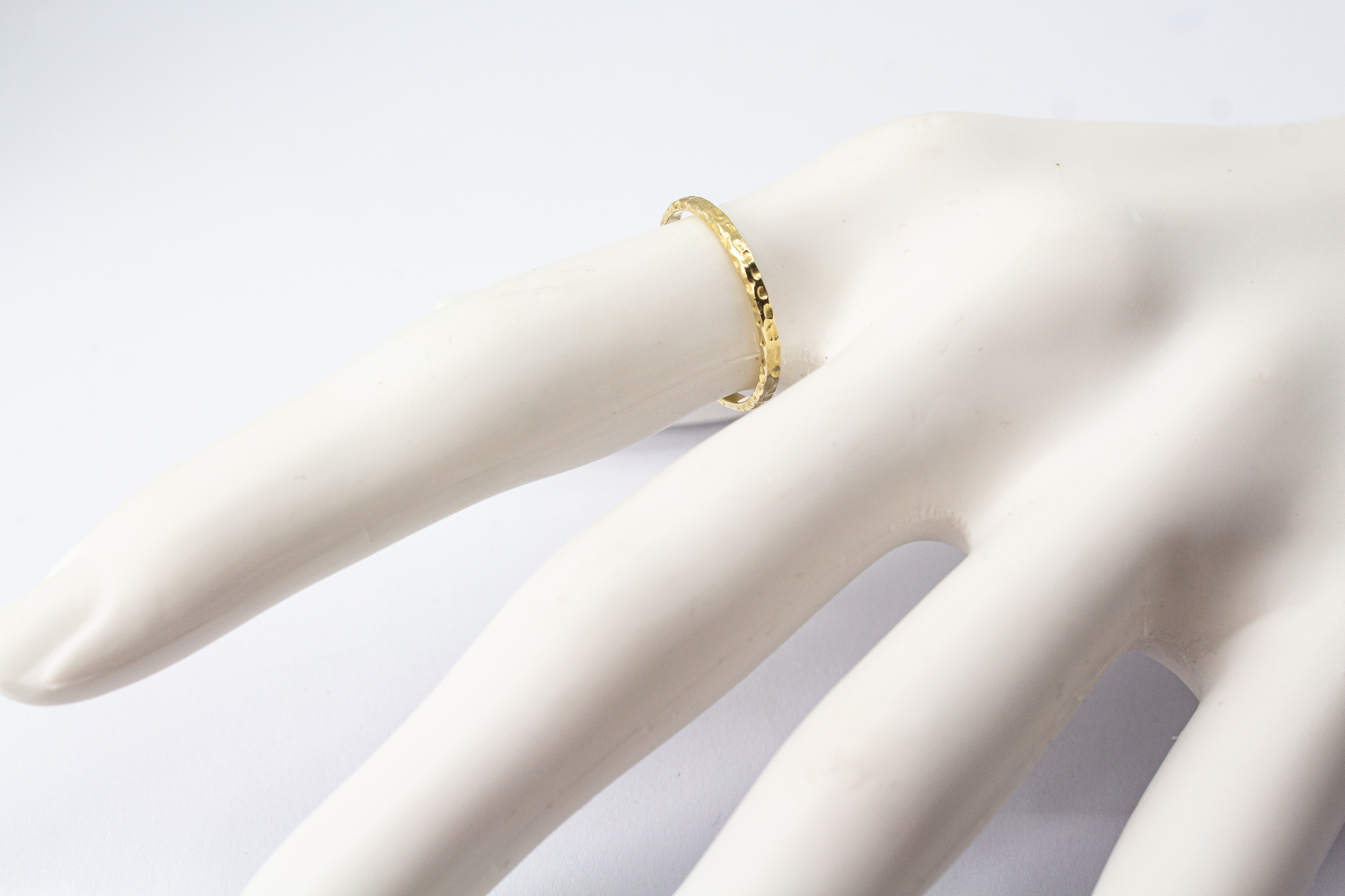 Schmaler, vergoldeter Ring aus 925er Silber mit einer markanten Oberfläche in Hammerschlagoptik im Onlineshop von Goldschmiede Regina Kraus.