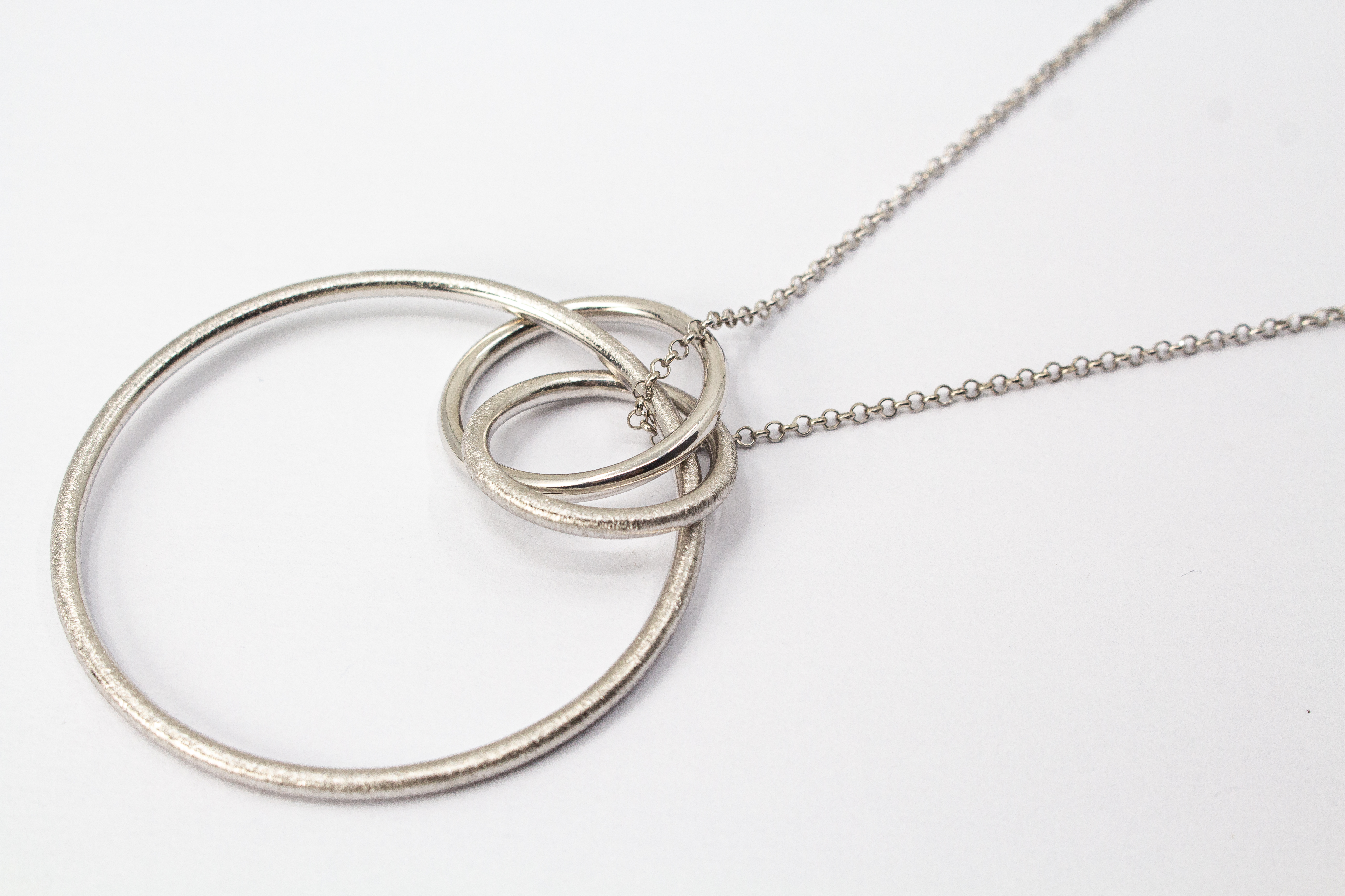 Modernes Collier aus rhodiniertem 925er Sterlingsilber von Diva Gioielli mit einem Anhänger aus mehreren ineinander verschlungenen Ringen in glänzender und eismatter Optik