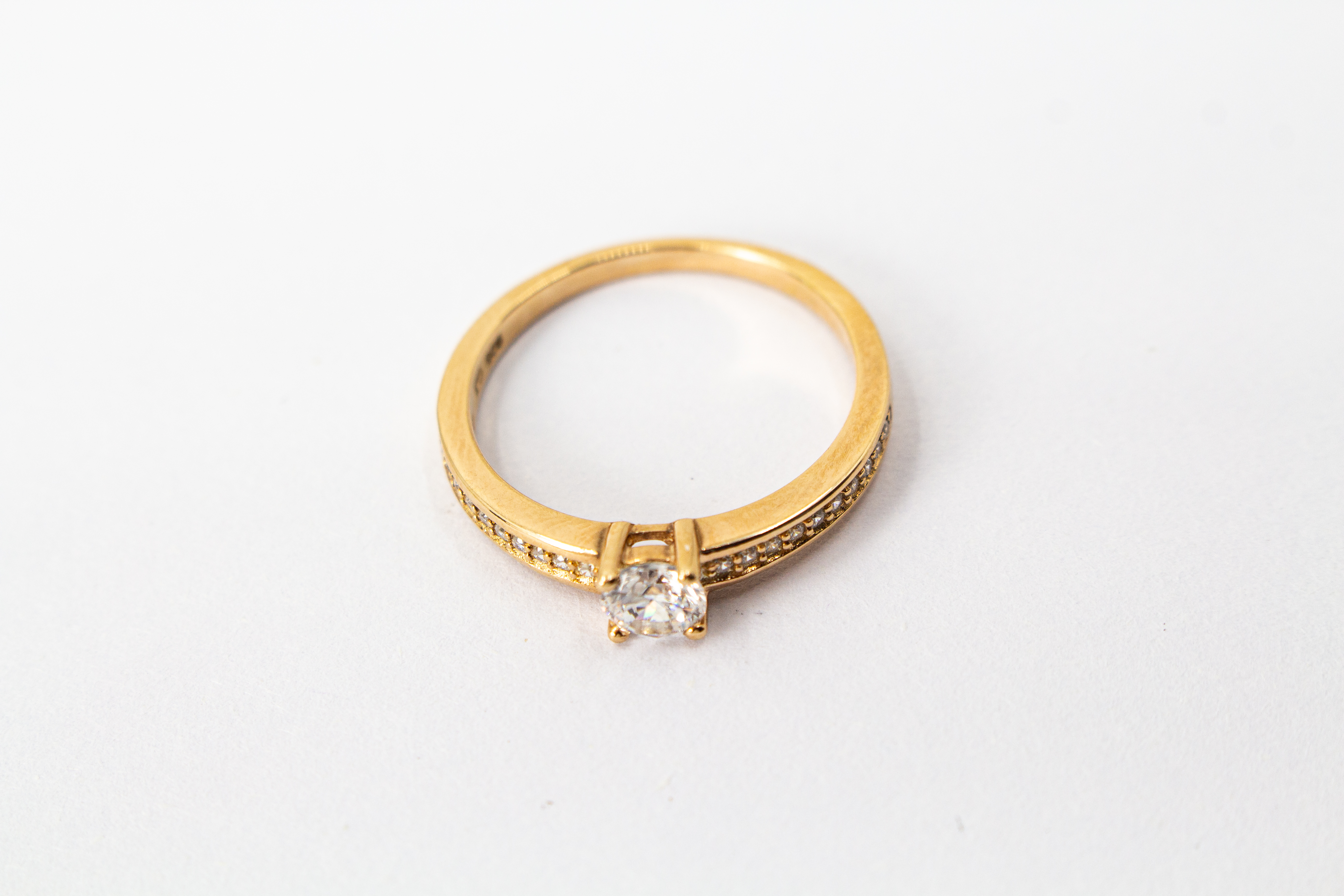 Eleganter Damenring aus rosévergoldetem 925 Sterling Silber mit einem großen, rund facettierten Zirkonia-Hauptstein in einer klassischen Vier-Krappenfassung und einer mit kleinen Zirkoniasteinen im Pavé-Stil besetzten Ringschiene aus dem Online-Shop der G