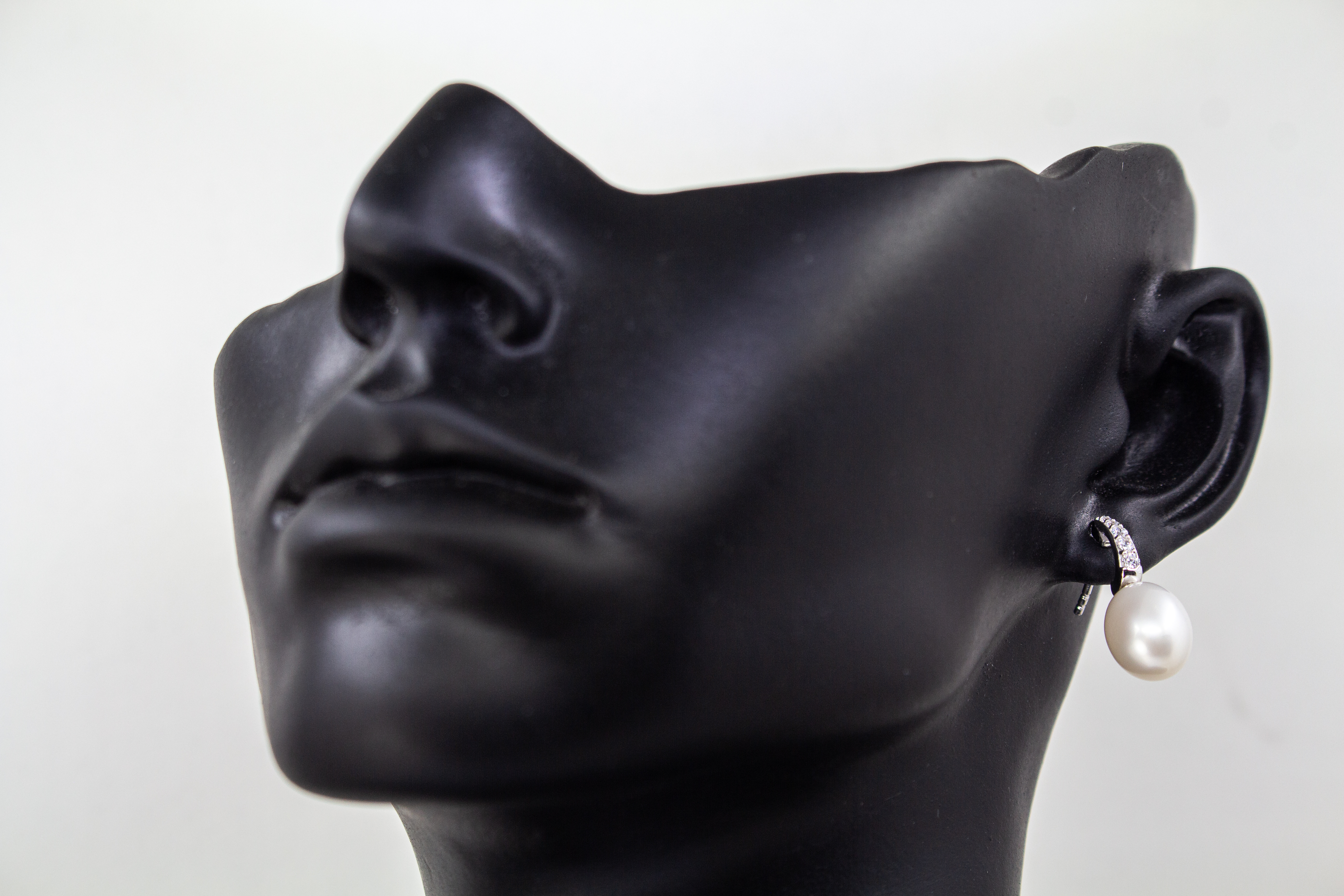 Geschwungene Ohrstecker aus rhodiniertem 925er Sterlingsilber, besetzt mit funkelnden Zirkonia und einer weißen Süßwasserzuchtperle