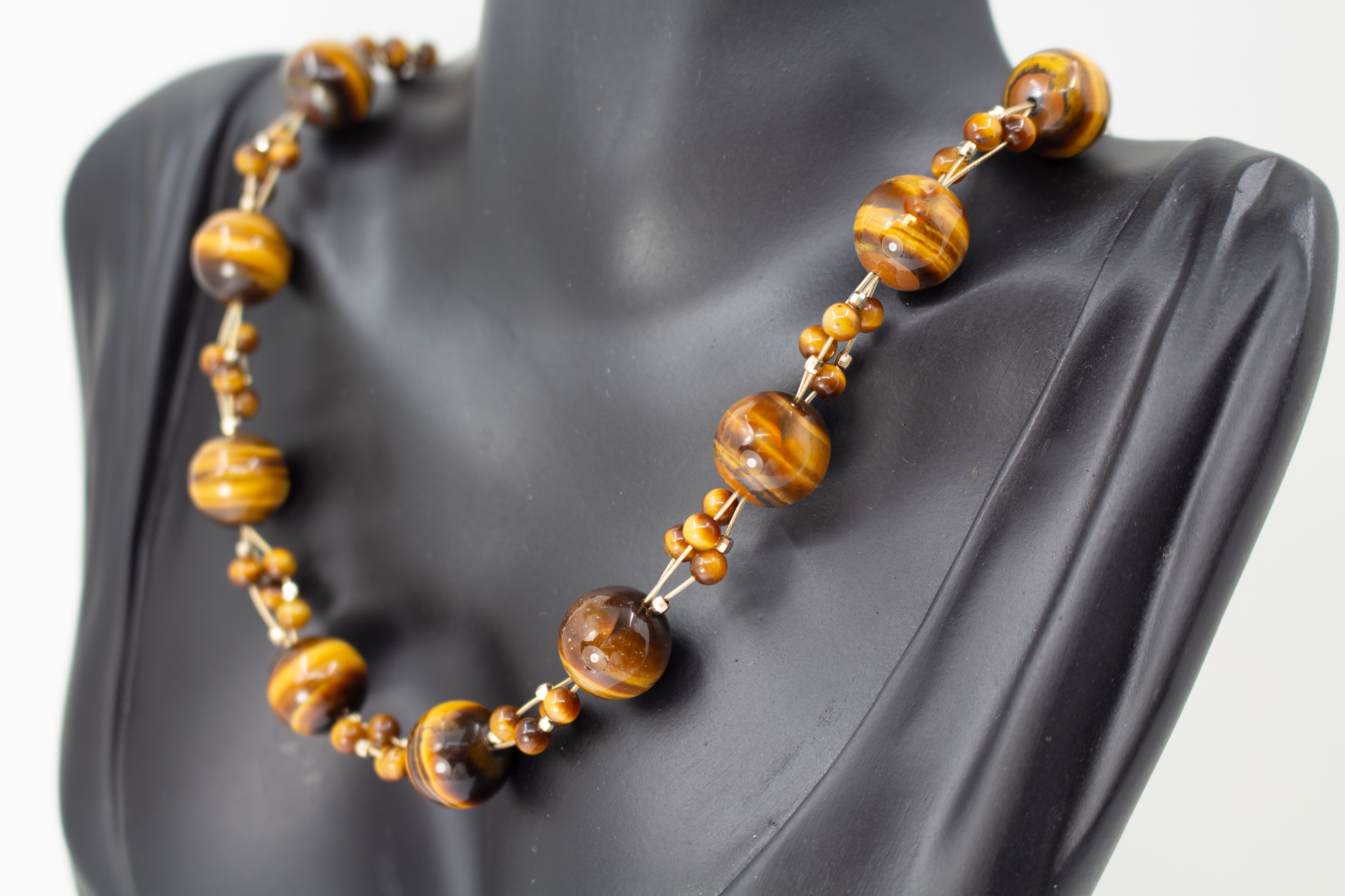 Eine handgefertigte Edelsteinkette der Goldschmiede Regina Kraus aus runden, braungoldenen Tigerauge-Perlen