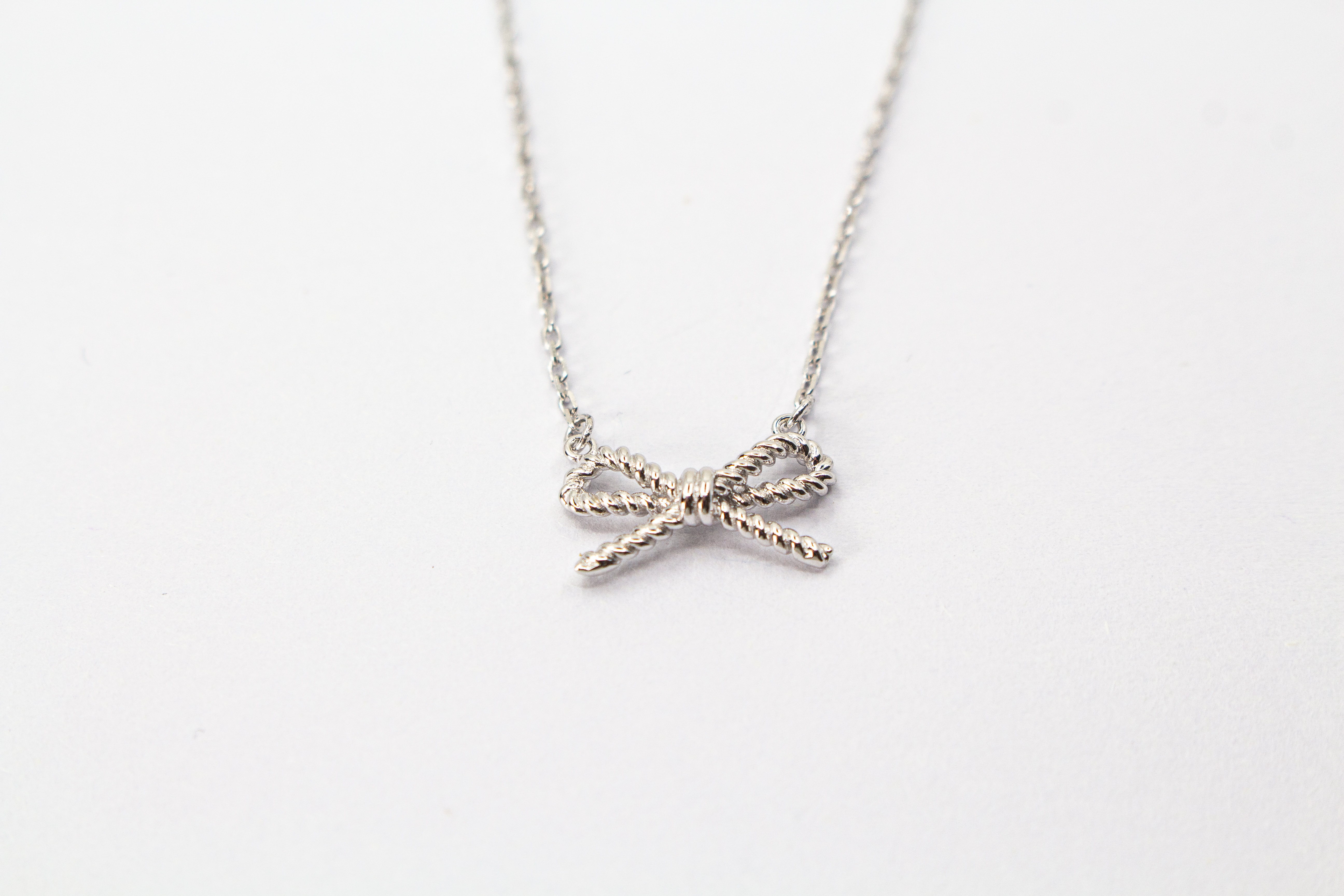 Collier „Schleifenzauber“ aus rhodiniertem 925er Sterlingsilber mit filigranem Schleifenanhänger in zeitlosem Design.