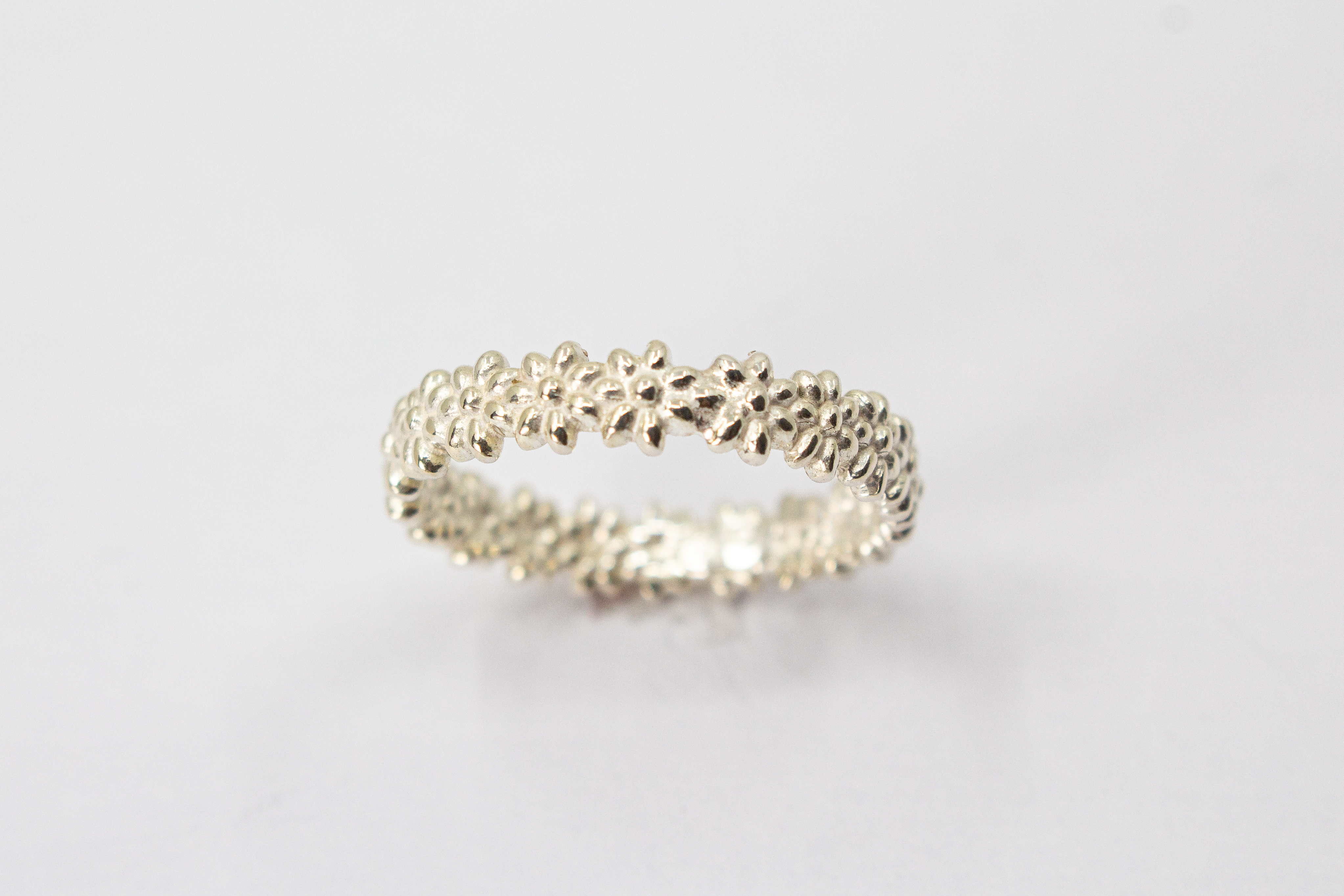 Schmaler, filigraner Ring aus 925 Sterling Silber mit einem rundherum verlaufenden, detaillierten Blütenmuster von der Goldschmiede Regina Kraus
