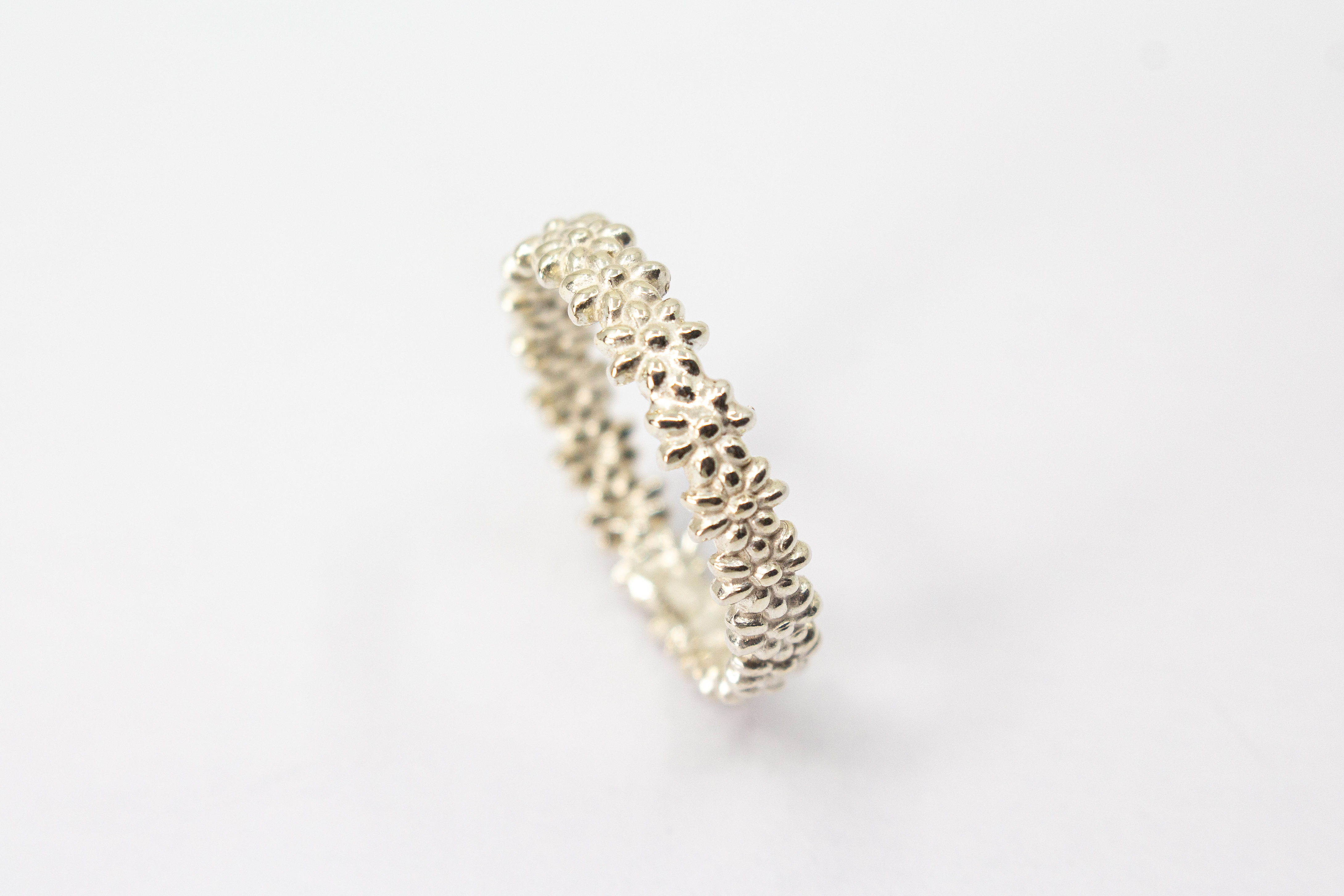 Schmaler, filigraner Ring aus 925 Sterling Silber mit einem rundherum verlaufenden, detaillierten Blütenmuster von der Goldschmiede Regina Kraus