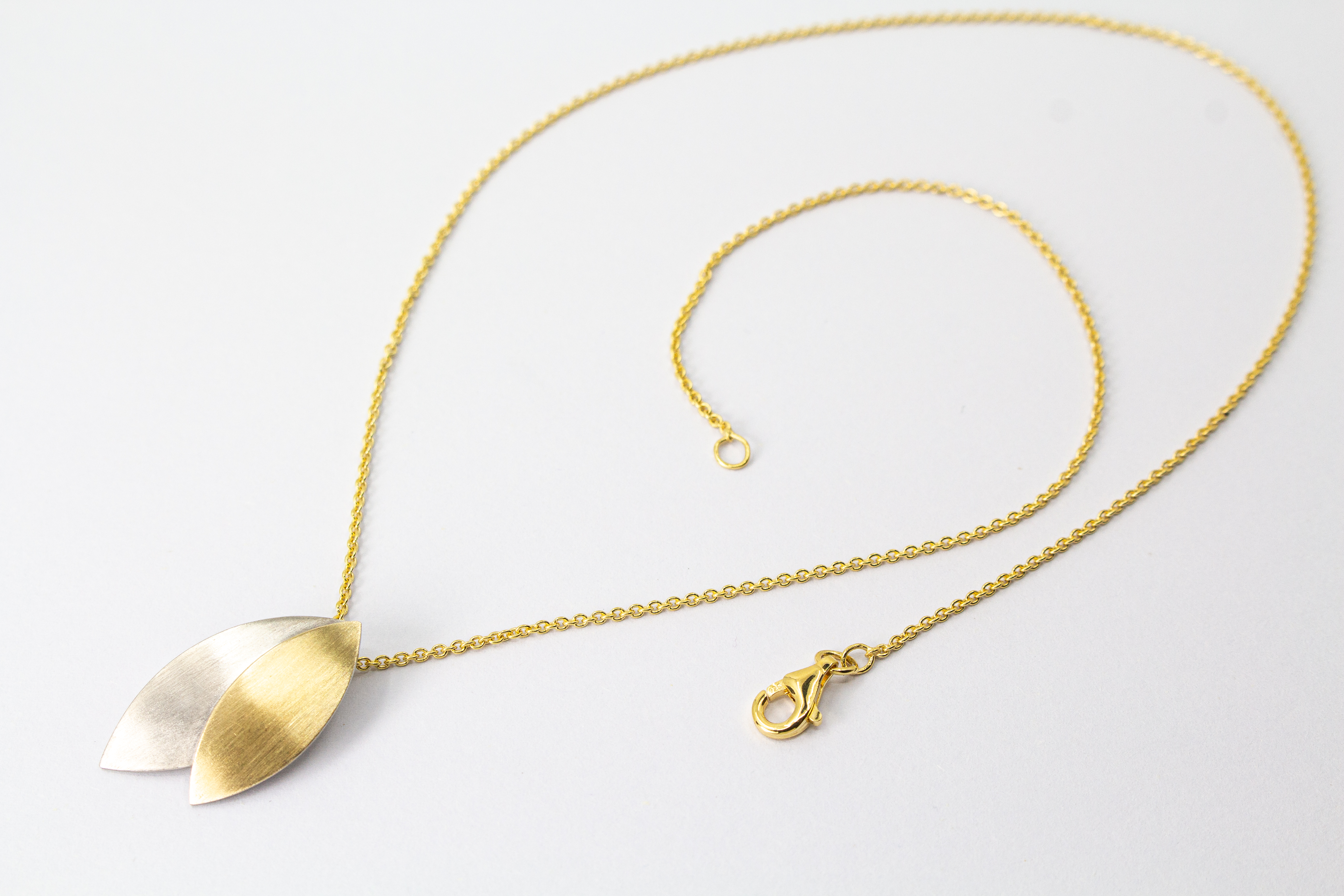 Kette „Blattgold“ aus 925er Sterlingsilber mit Feingoldbelötung und zweifarbigem Anhänger in filigraner Blattform.