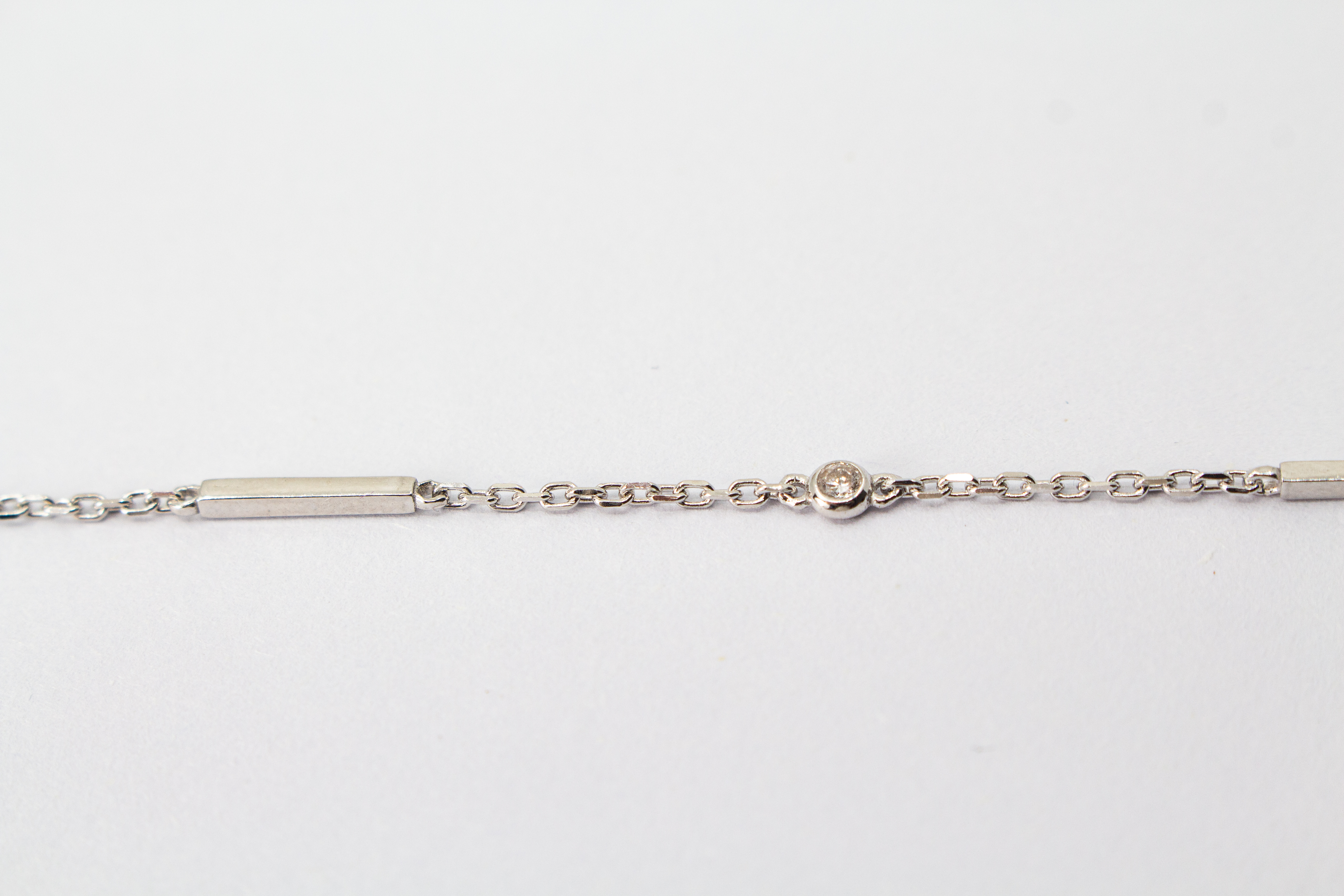 Filigranes, rhodiniertes Damen-Armkettchen aus 925 Sterling Silber mit kleinen, rund gefassten Zirkonia-Steinen und glatten, minimalistischen Stäbchen-Elementen aus dem Online-Shop der Goldschmiede Regina Kraus.