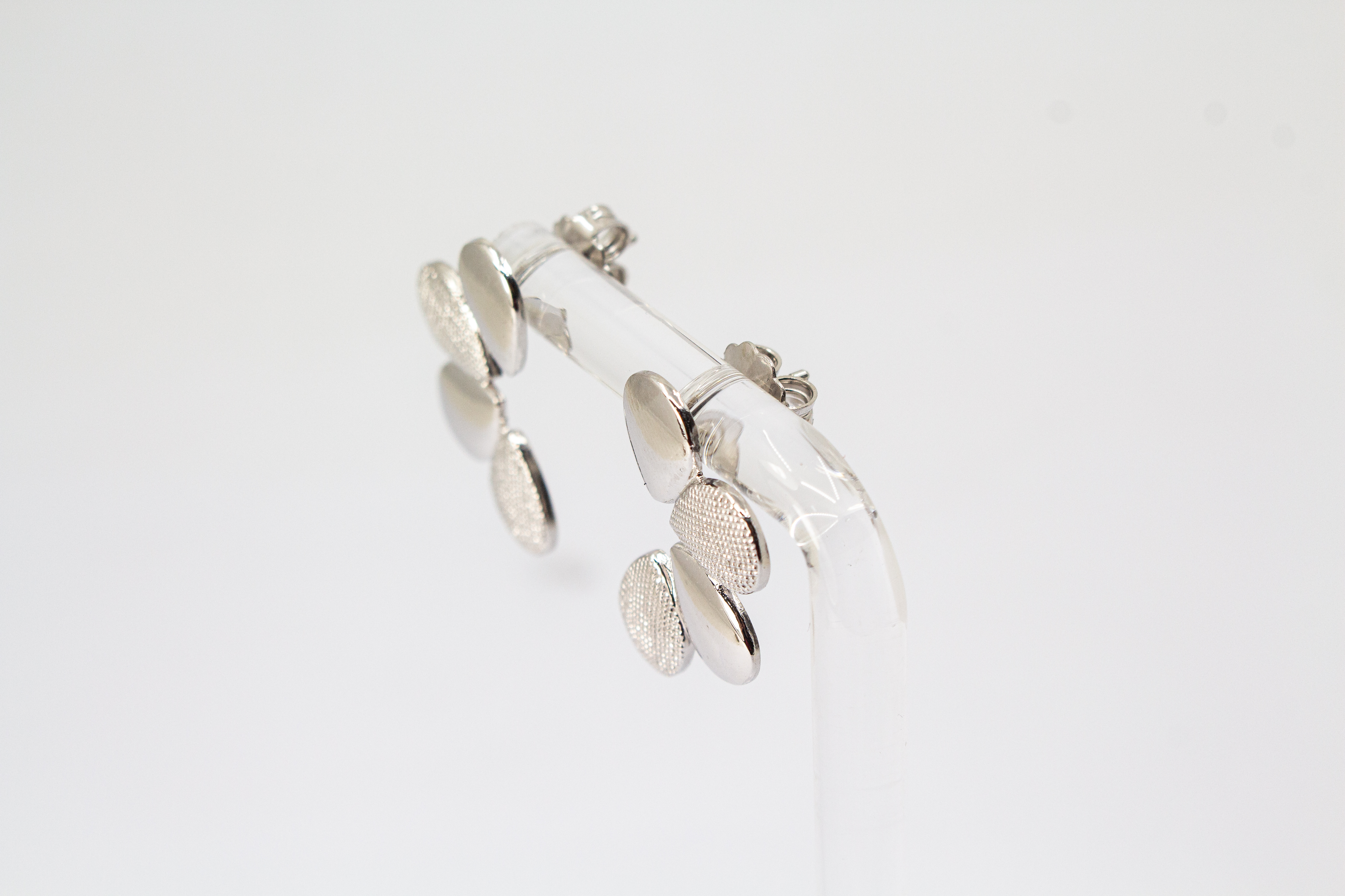 Moderne Ohrstecker der Cosmic Drop Serie von Diva Gioielli aus rhodiniertem 925 Silber. Die Ohrringe zeigen eine fächerförmige Anordnung von glatten und punktförmig strukturierten Tropfen