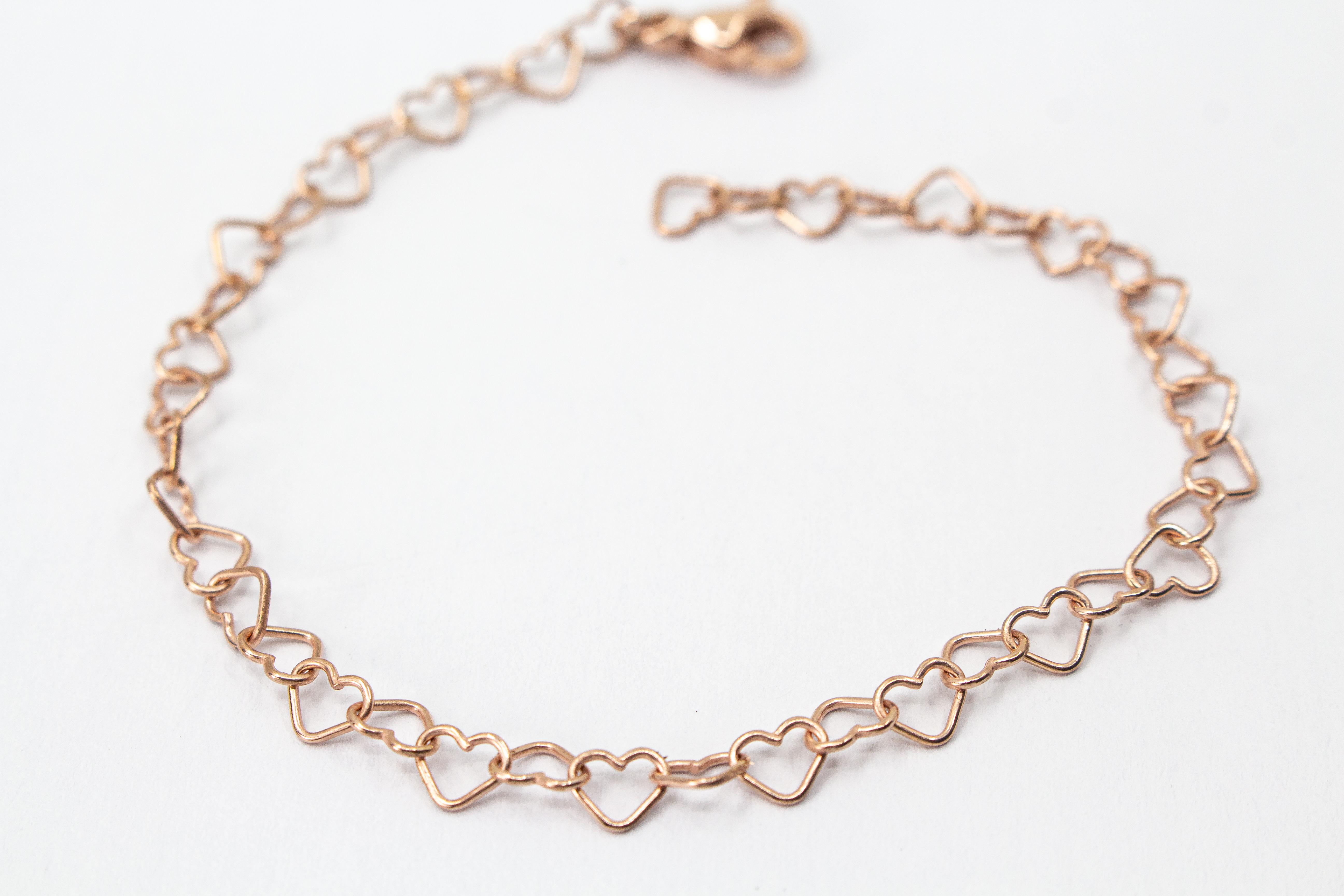 Filigranes Kettenglieder-Armband „Herz an Herz“ aus 20 Mikron rosé vergoldetem 925er Sterlingsilber, exklusiv erhältlich im Schmuck-Onlineshop der Goldschmiede Regina Kraus.