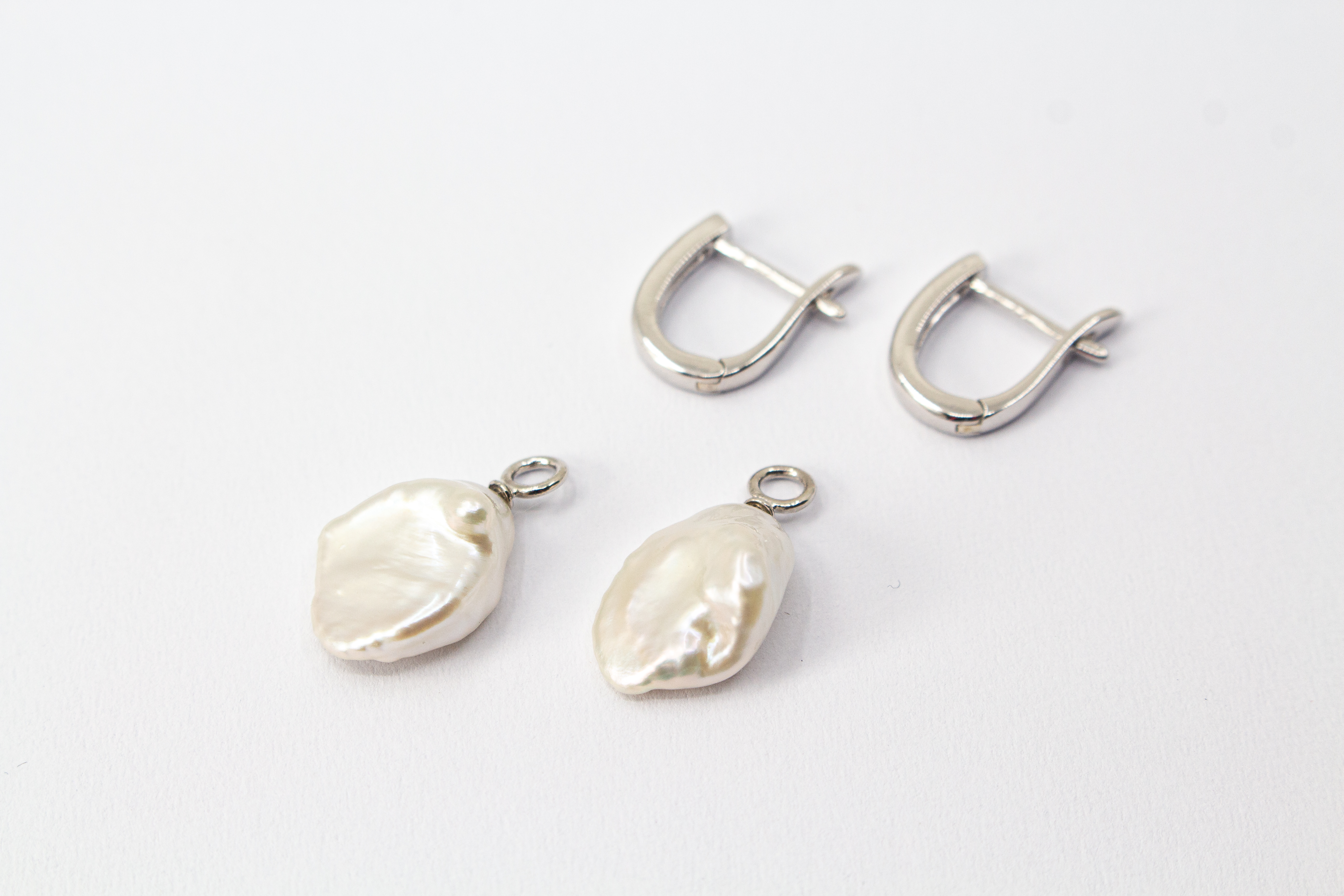 Elegante Wechselcreolen aus rhodiniertem 925er Sterlingsilber mit barocken Keshiperlen-Anhängern