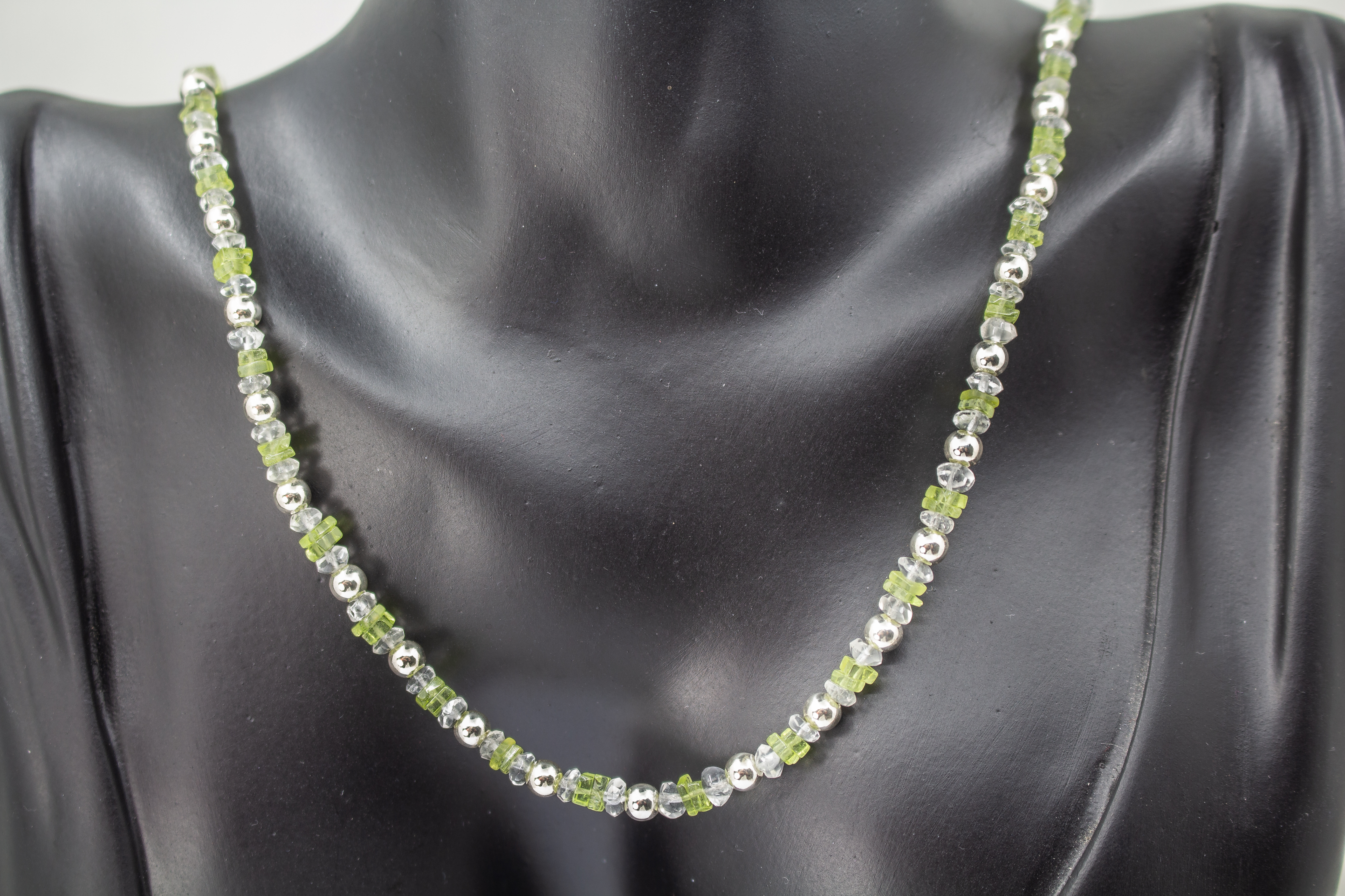Filigrane Edelsteinhalskette aus hellgrünen Peridot-Splittern, klaren Bergkristall-Elementen und glänzenden 925 Sterling Silberkugeln aus dem Online-Shop der Goldschmiede Regina Kraus