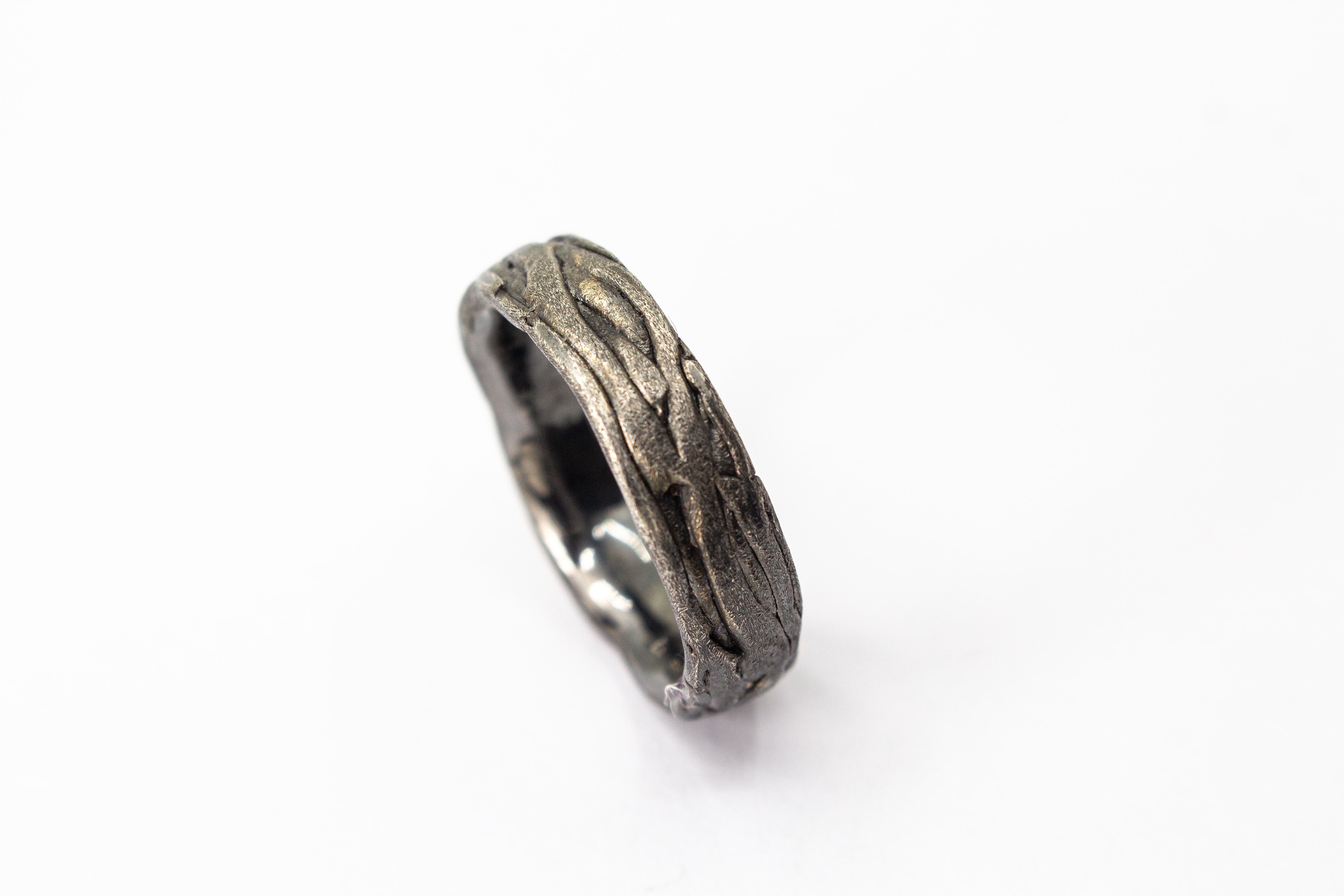 Markanter, strukturierter Bandring aus dunkel geschwärztem und oxidiertem 925 Sterlingsilber mit einer organisch geflochtenen Oberfläche im Ast- oder Rinden-Design aus dem Online-Shop der Goldschmiede Regina Kraus.
