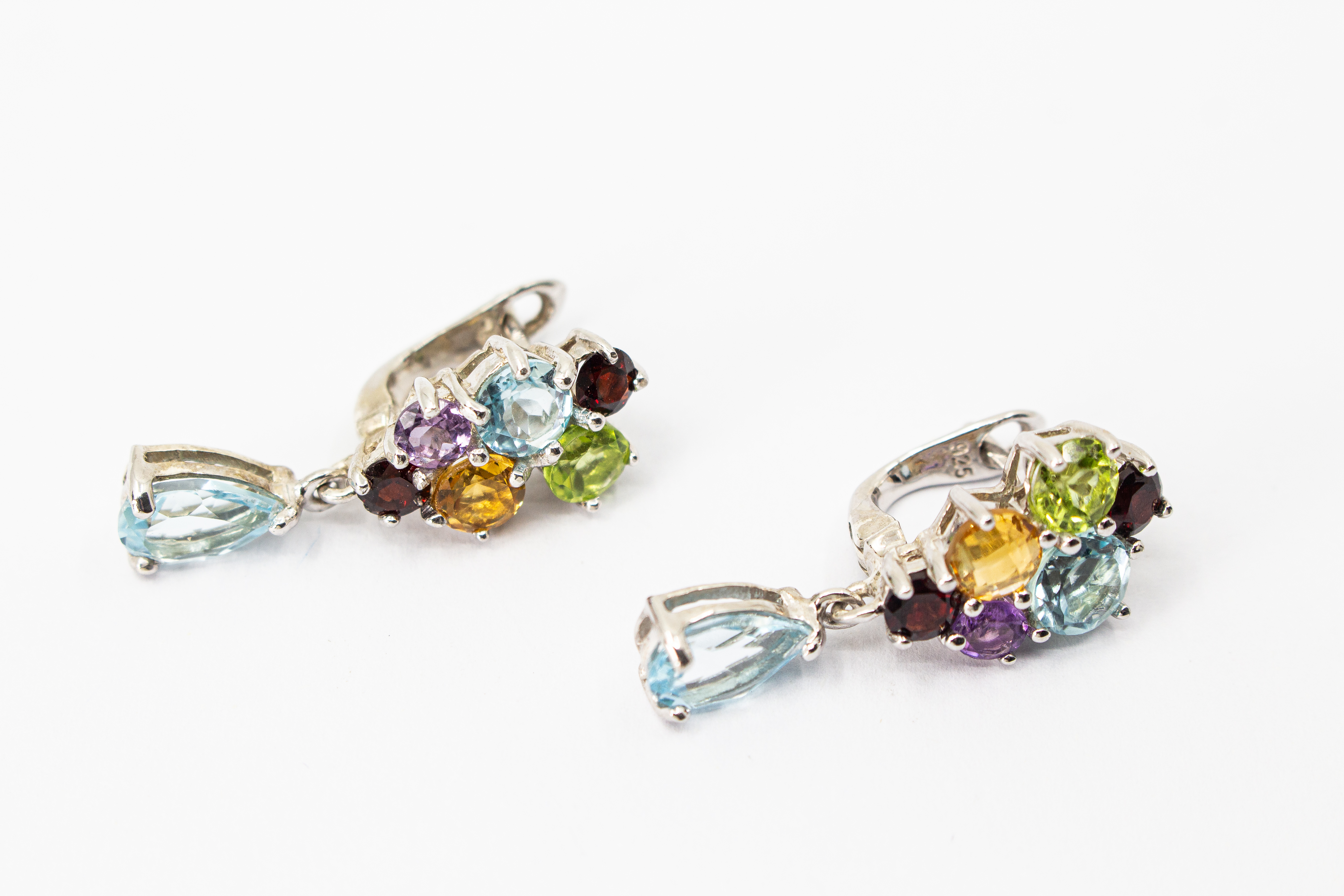 Elegante Multicolor-Edelstein-Ohrhänger aus rhodiniertem 925 Silber von der Goldschmiede Regina Kraus. Die detailreichen Ohrringe zeigen ein farbenfrohes Cluster aus rund facettierten Steinen wie Amethyst, Peridot, Citrin und Granat, gefolgt von einem bew